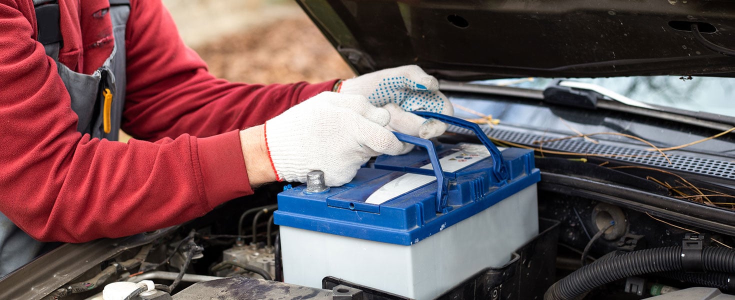 mechanic replaces the car battery. Discharging the battery and repairing the car.