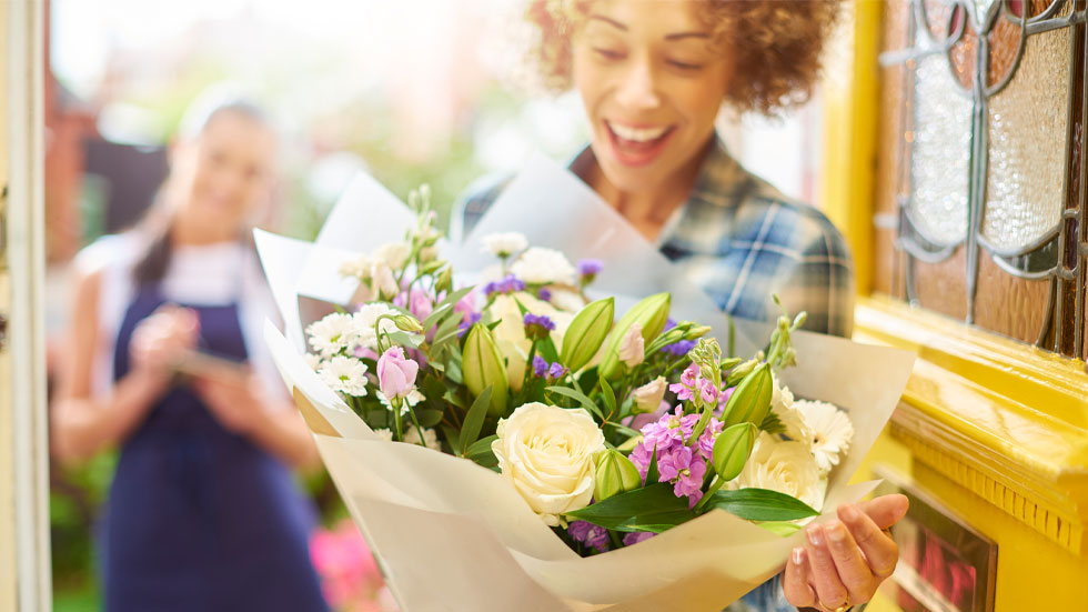 Woman getting flowers at her house