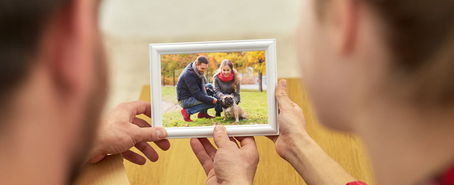 Couple looking at photo of them with dog