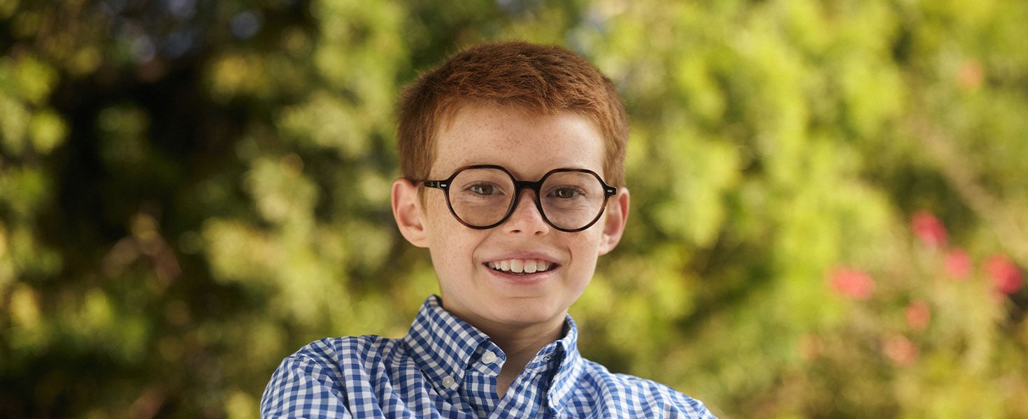 Little boy wearing glasses, holding smart phone