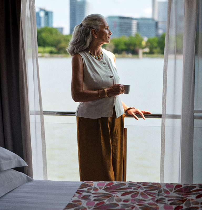 woman on balcony in cruise cabin