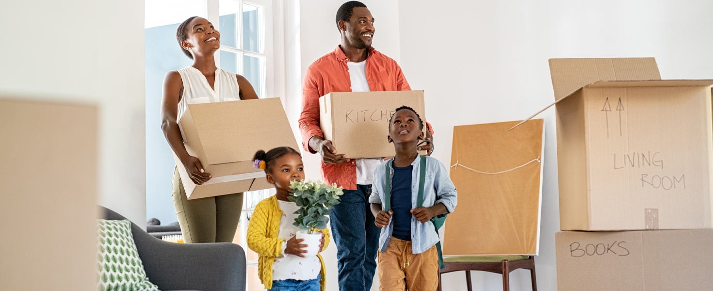 Family moving into a new home, holding boxes