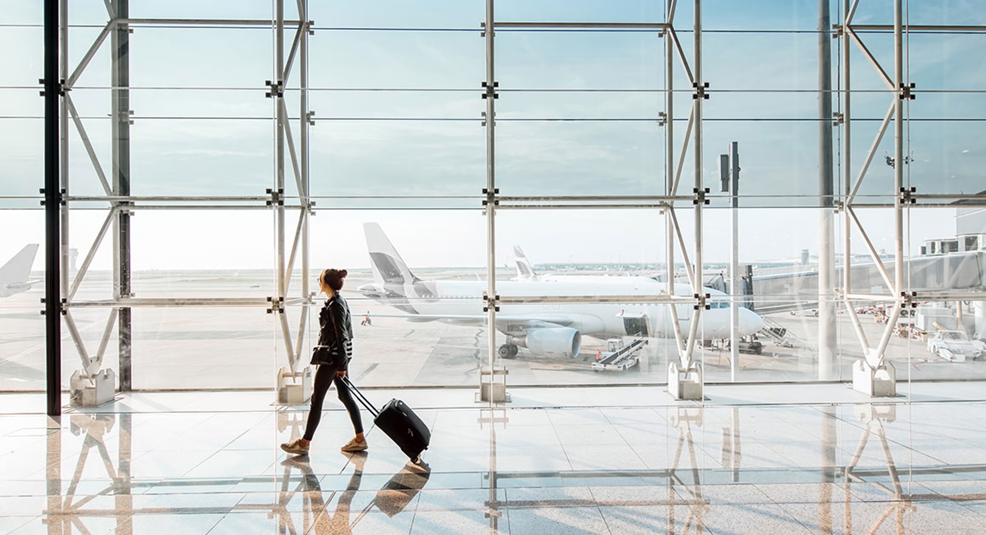 woman walking in airport with suitcase
