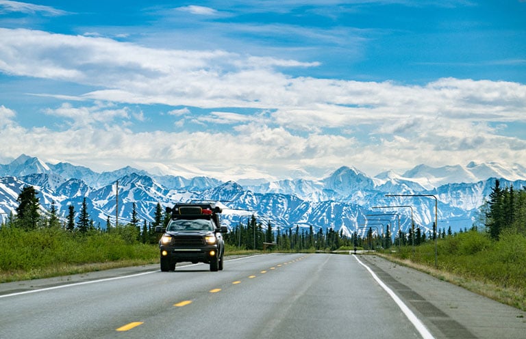 car on road, mountains in background