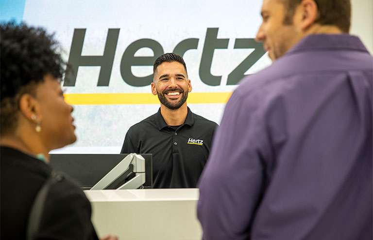 customers at counter in Hertz store