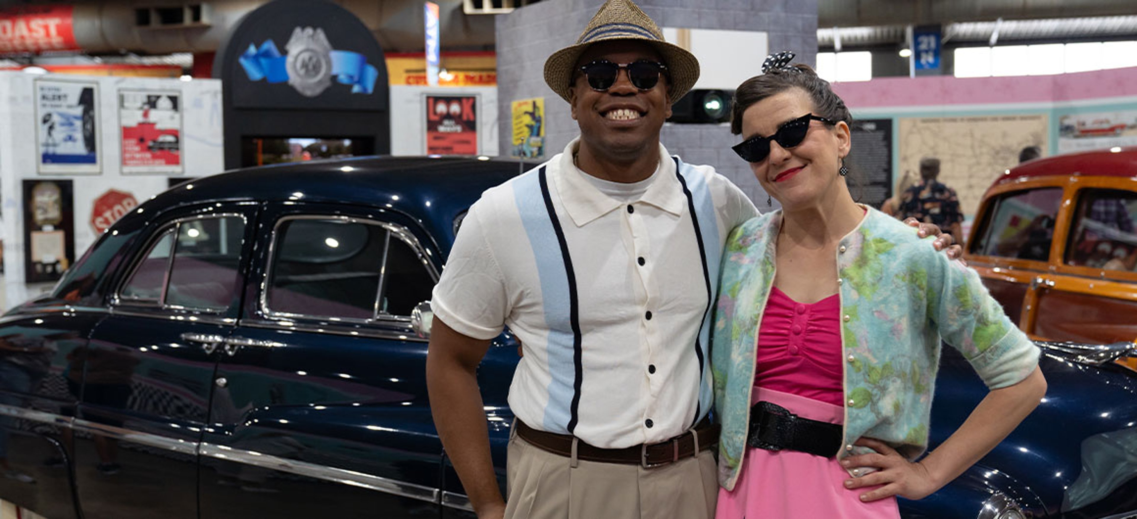 man and woman posing in front of classic car