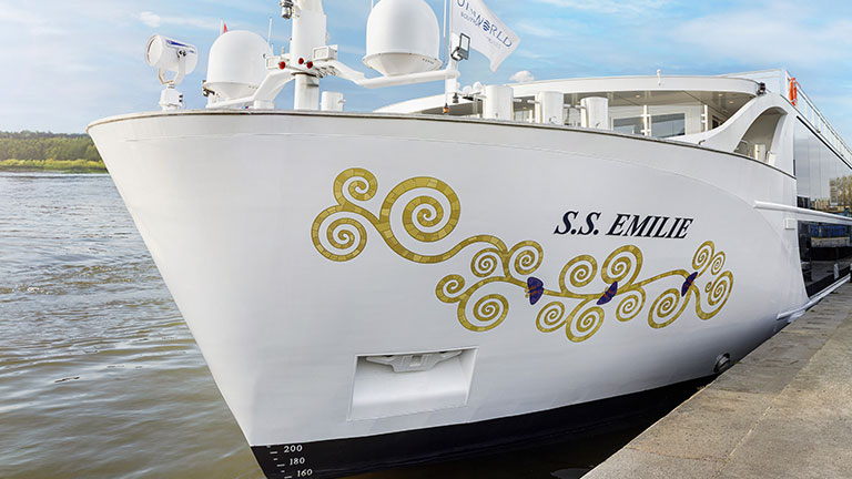 Bow of the white S.S. Emilie river cruise ship docked along the river.