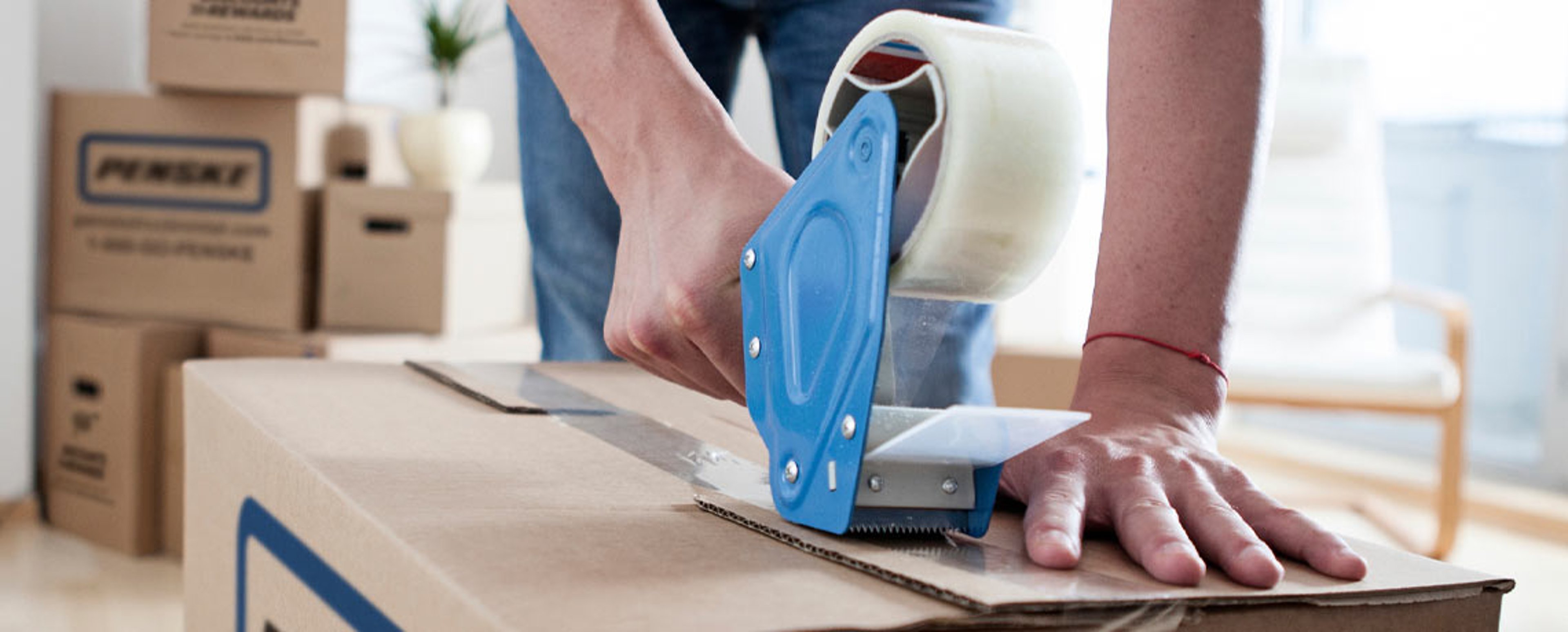 Individual taping a Penske moving box
