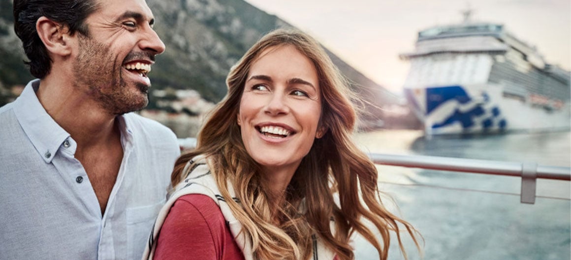 Man and woman smiling, Princess Cruises ship in background