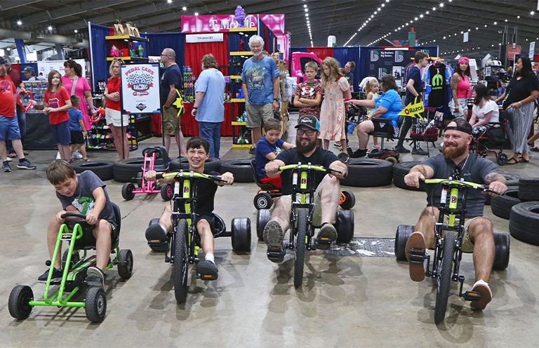 family having a tricycle race at Route 66 Road Fest