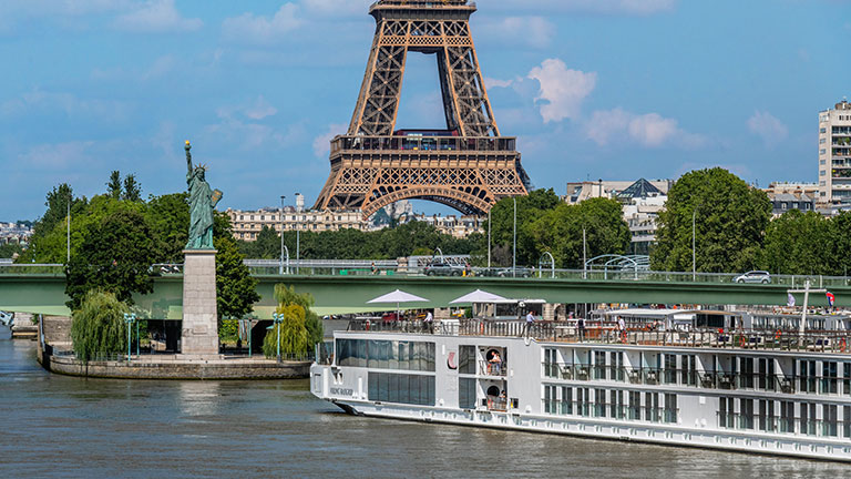 River cruise ship sailing past the Statue of Liberty in New York Harbor; photo courtesy of Viking