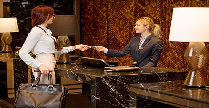 Female business traveler checking in at hotel front desk