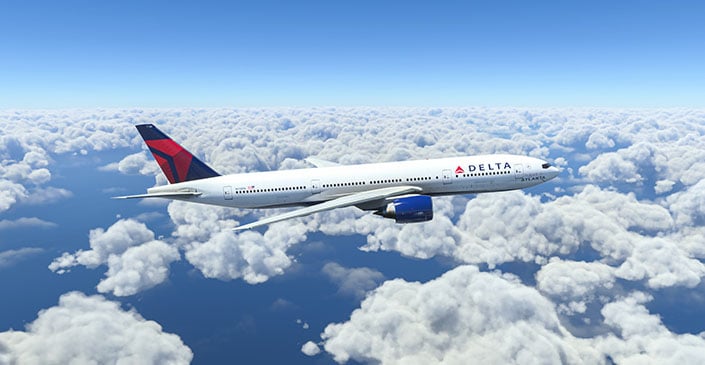 Commercial airplane flying over clouds with a blue sky.