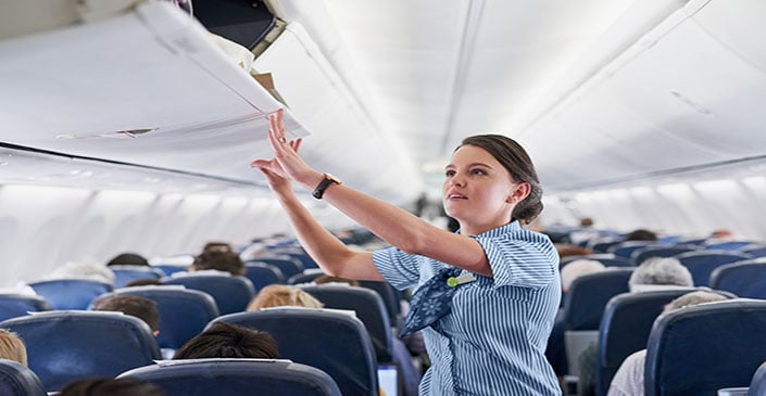 Flight attendant securing overhead bin