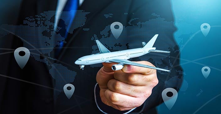 Hand holding a model airplane against a world map background with location pins.