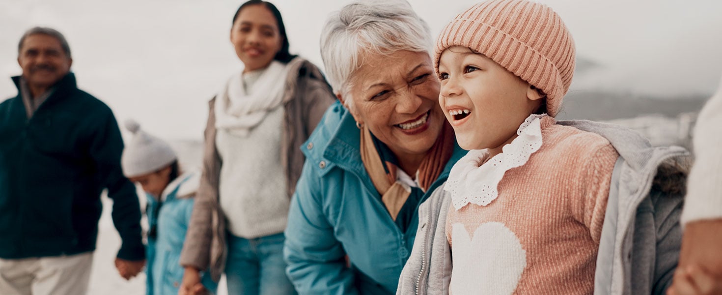Grandmother, girl and family at beach with smile, holding hands or outdoor with care, walk and vacation. People, generations and kids with laugh for funny conversation with bonding on winter holiday Credit:Jacob Wackerhausen