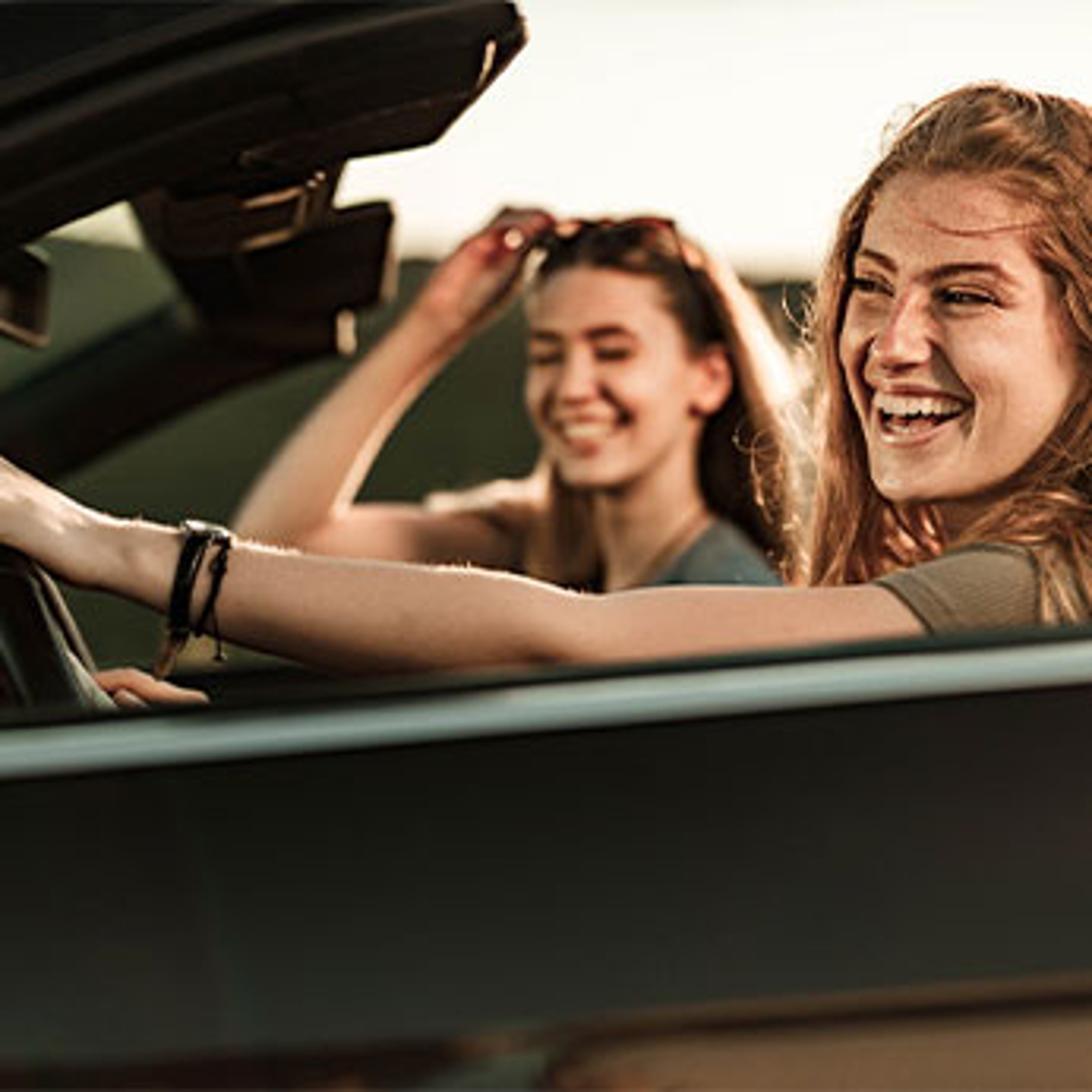 Two women driving in convertible car