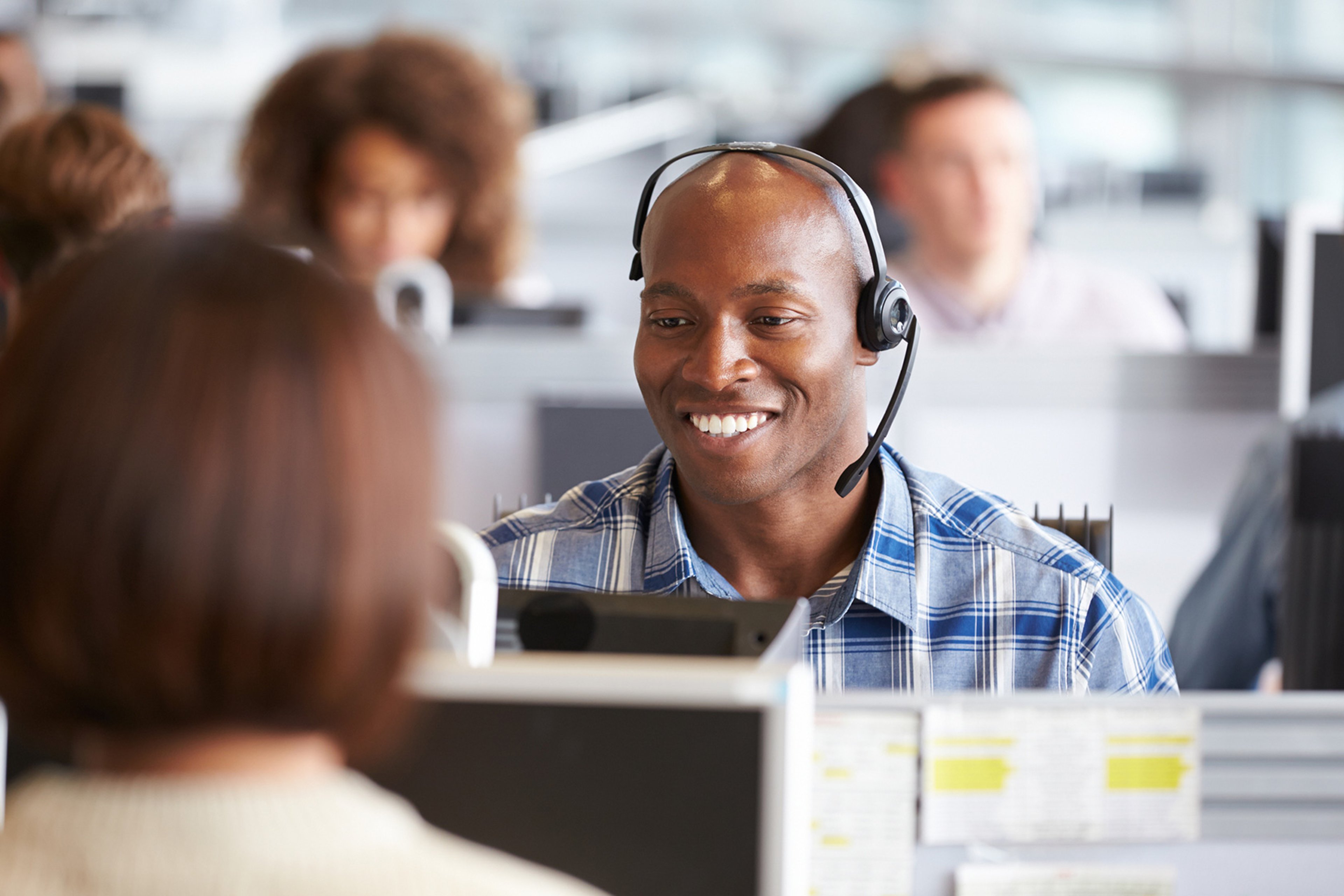 Smiling man with a headset working in a call center
