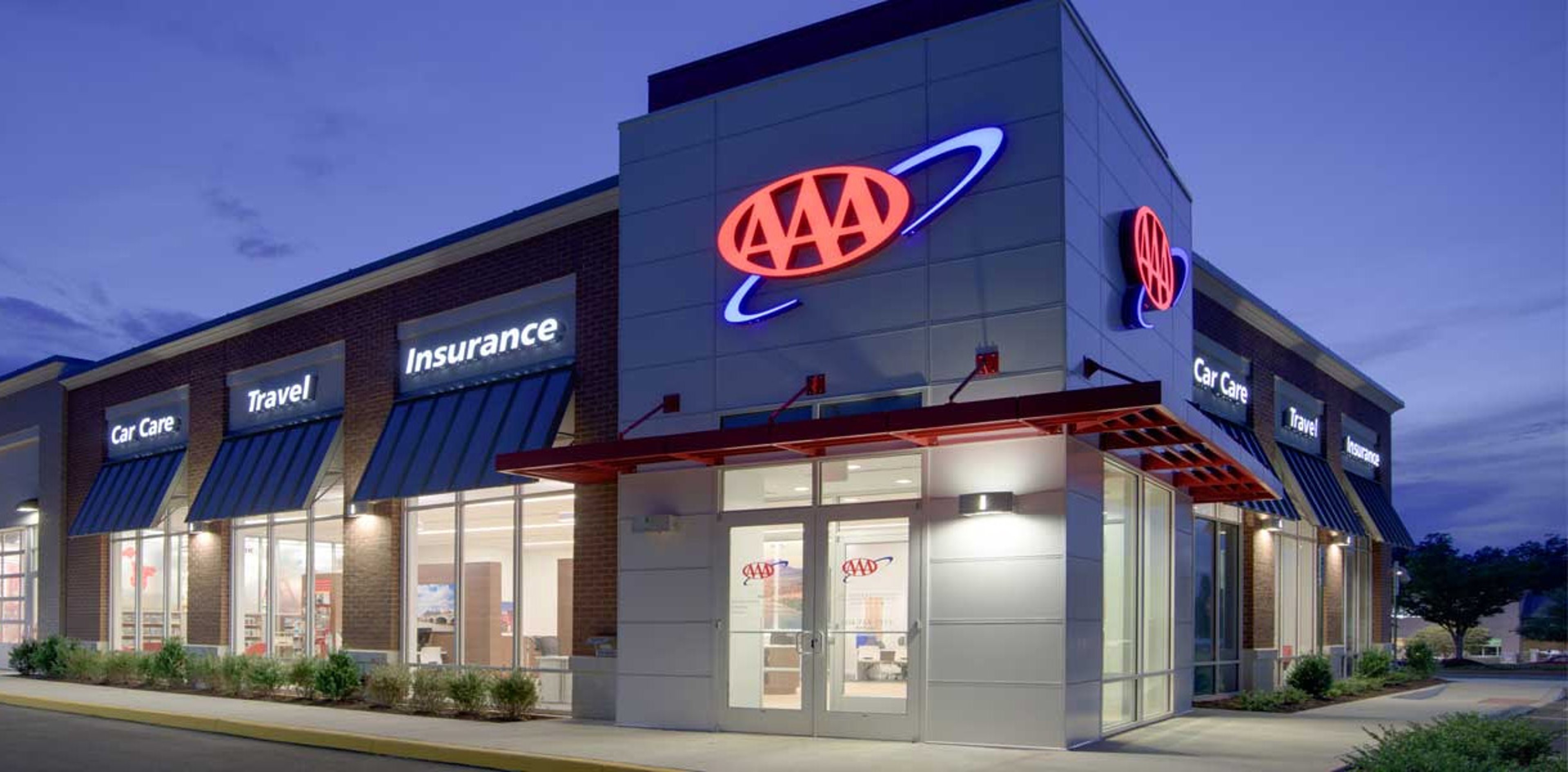 Photo of AAA Store with the lights on inside at twilight