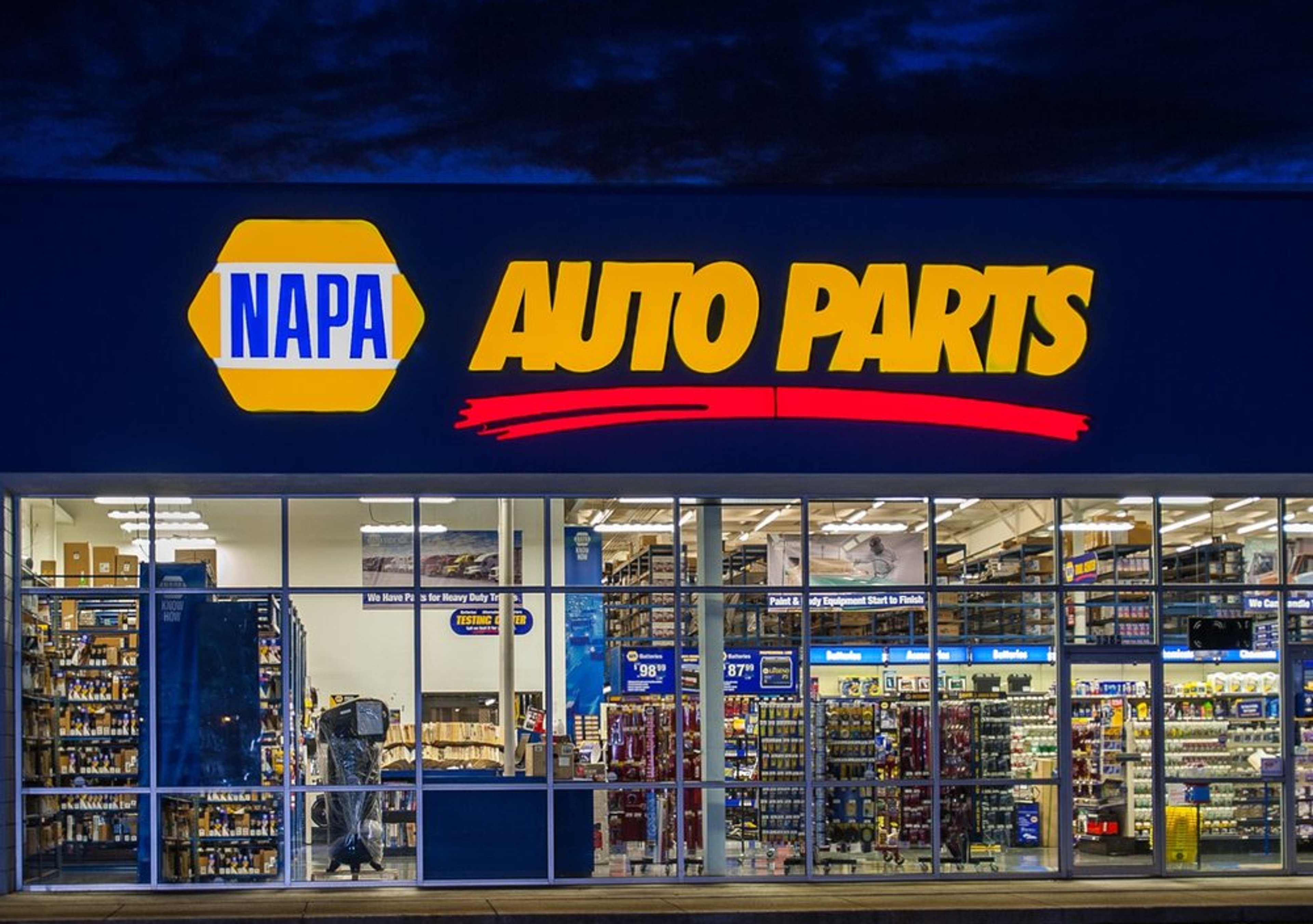 Nighttime illuminated storefront of NAPA Auto Parts location