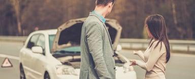 Couple looking at broken down car