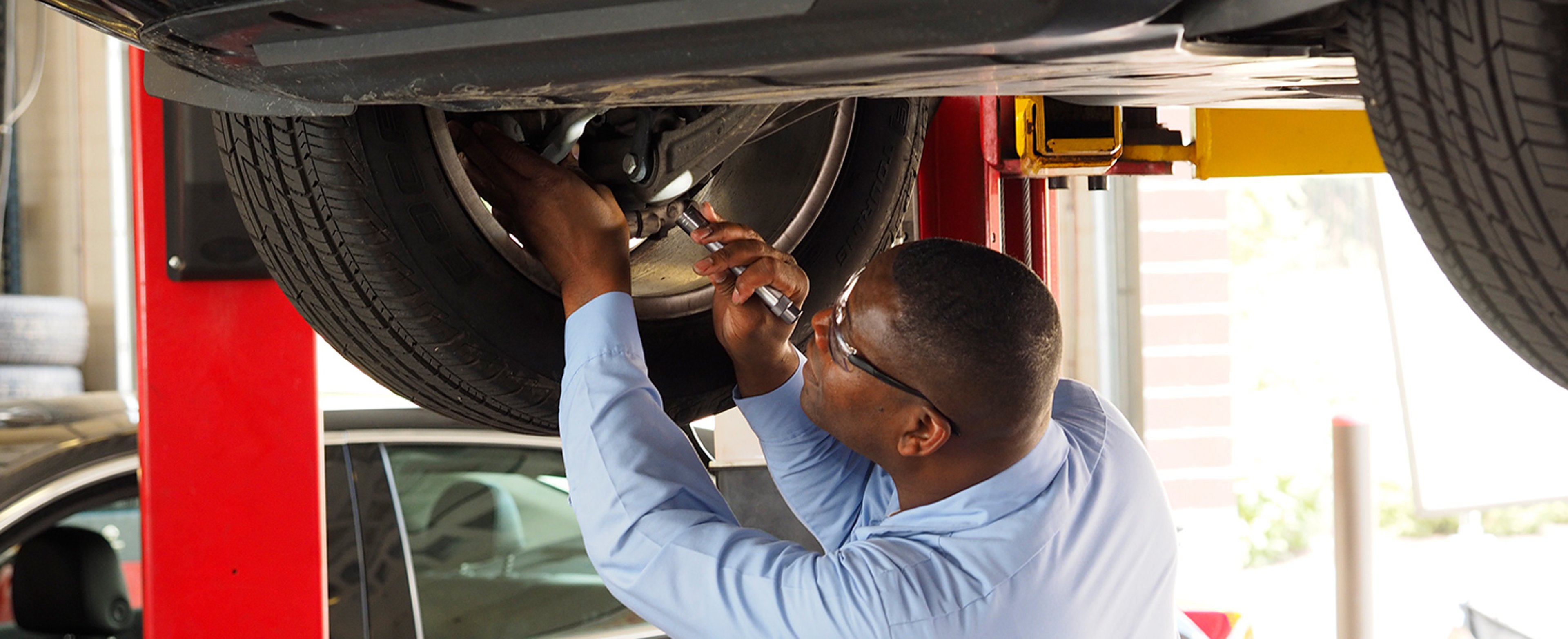 Mechanic fixing tire on car