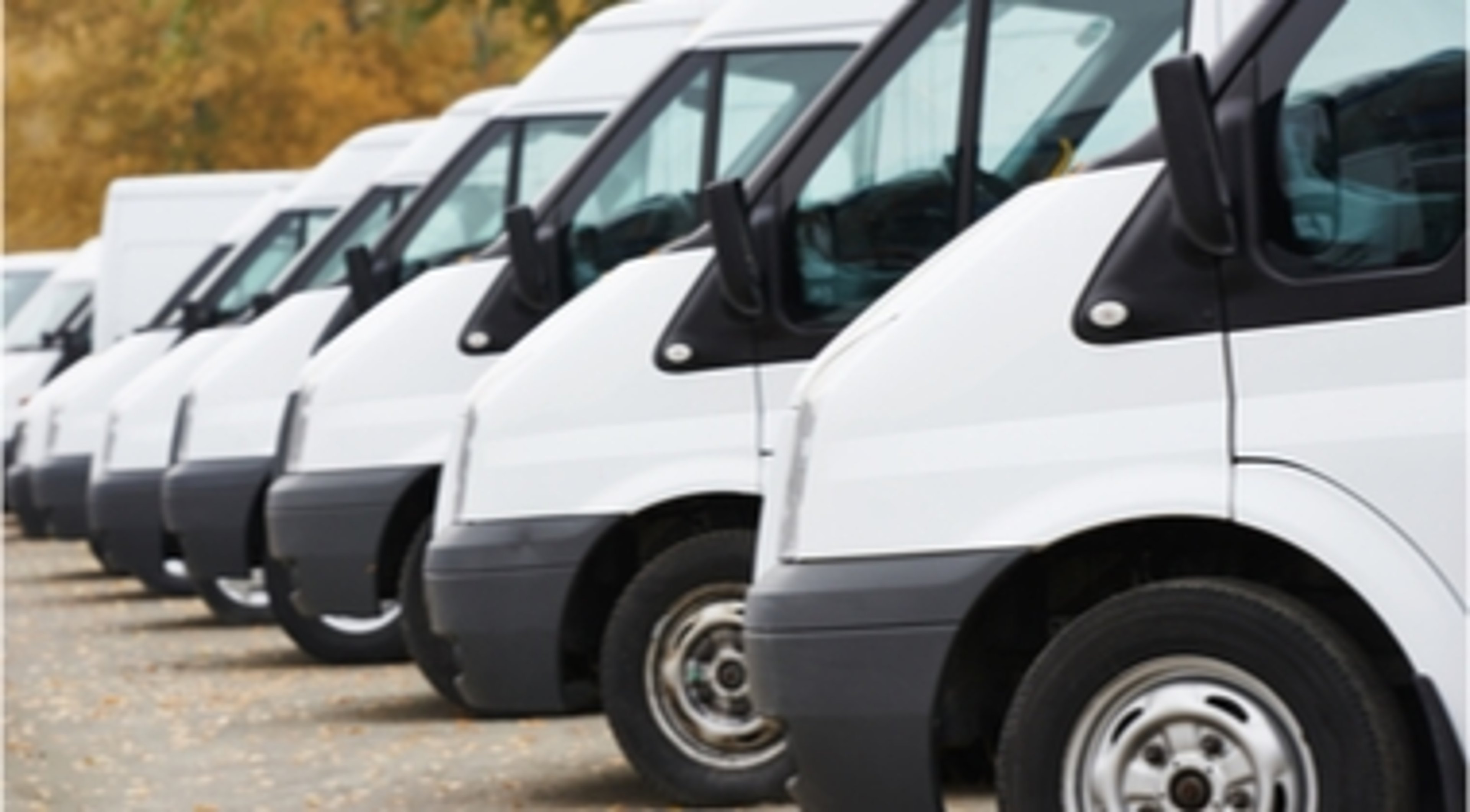 Row of white fleet vehicles parked at an angle