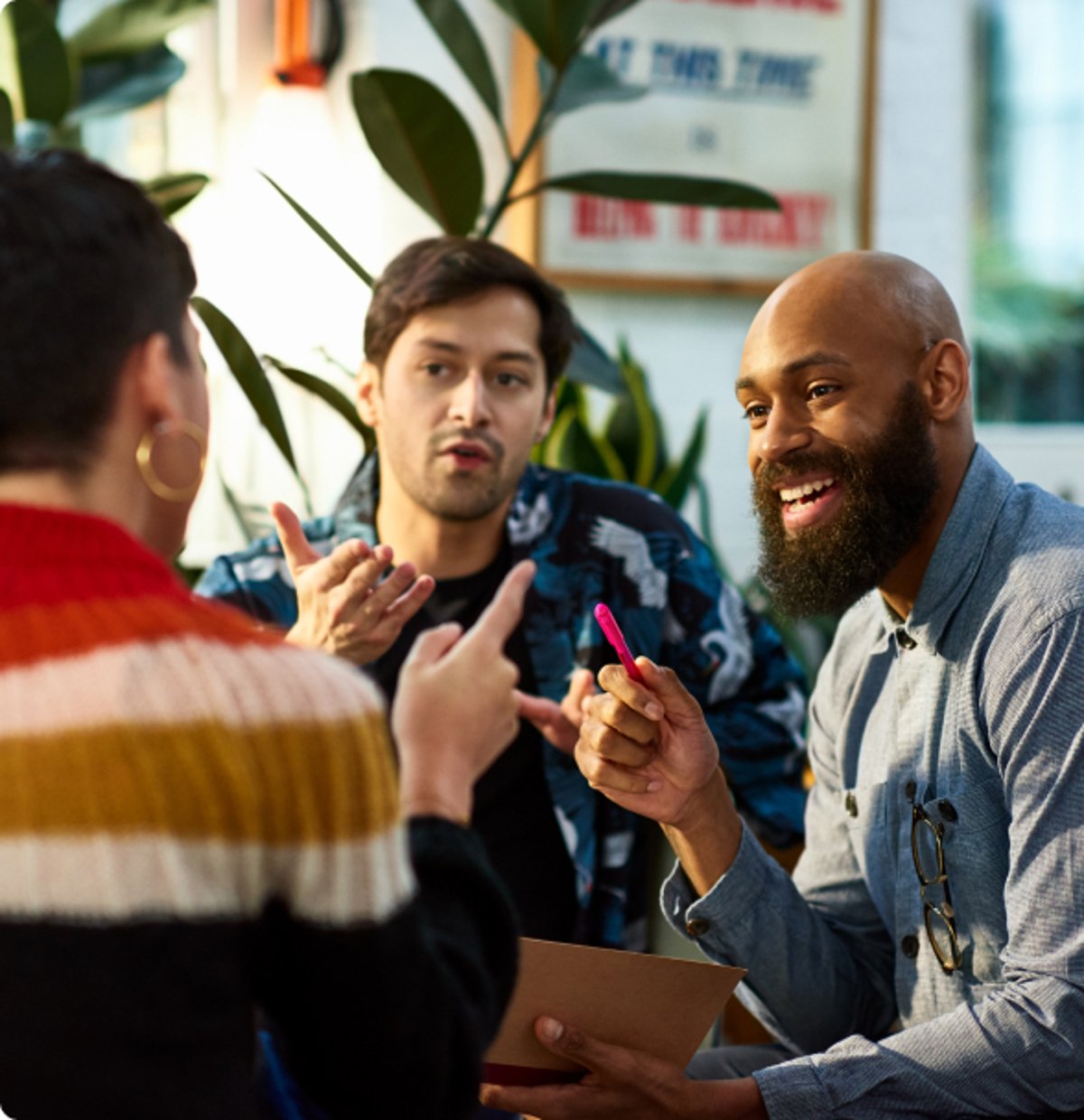 Three diverse colleagues engaged in a lively discussion, representing a collaborative and inclusive workplace culture.