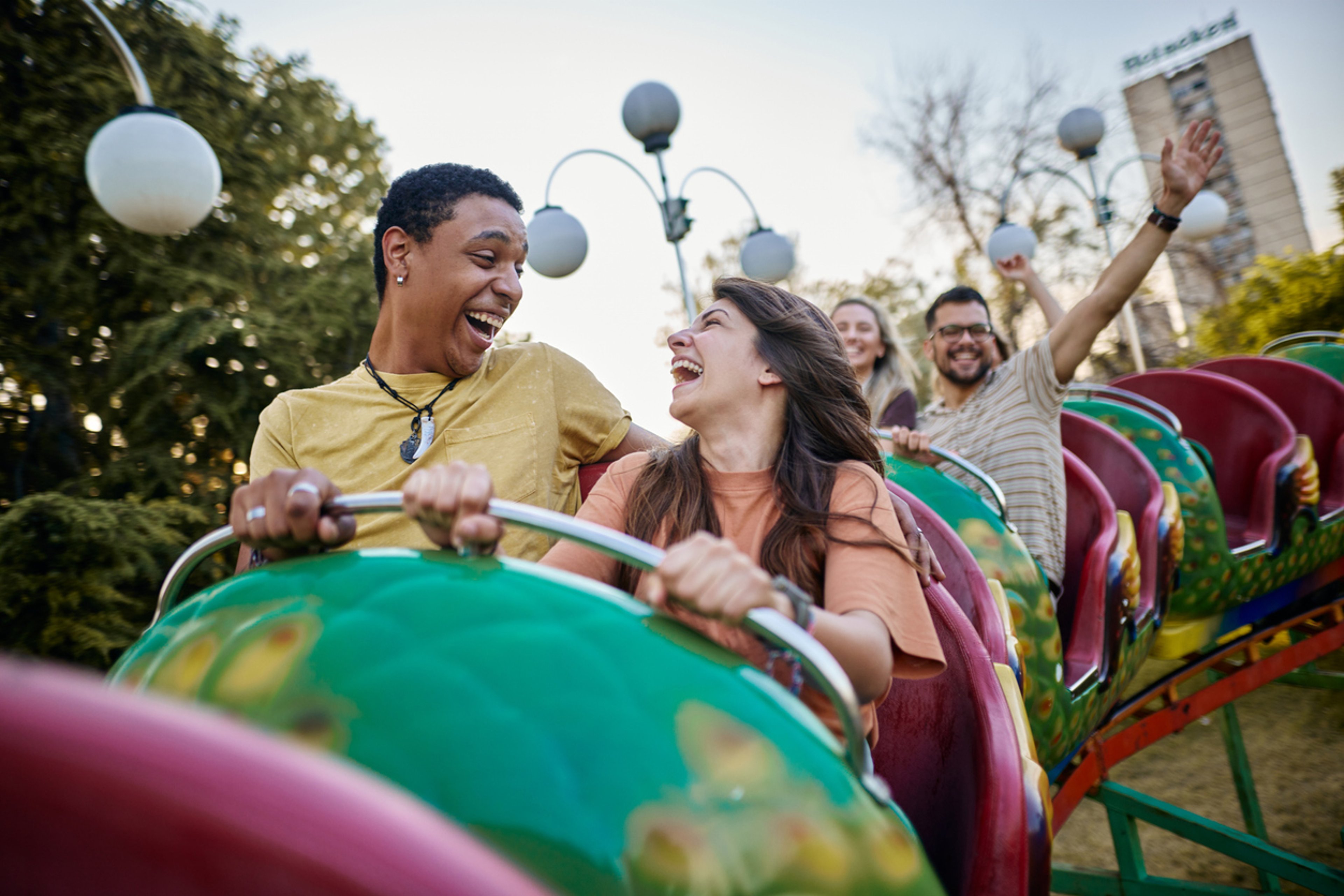A couple riding a rollercoaster and smiling 
