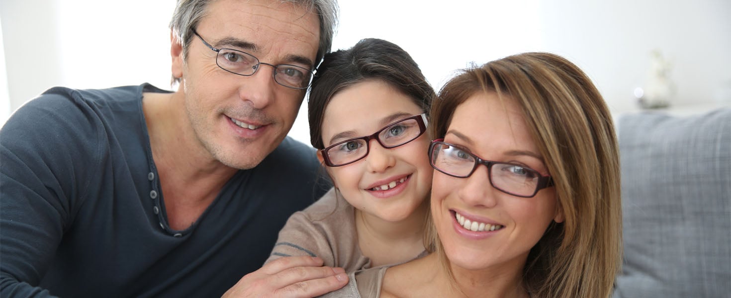 Smiling family of three smiling wearing eyeglasses