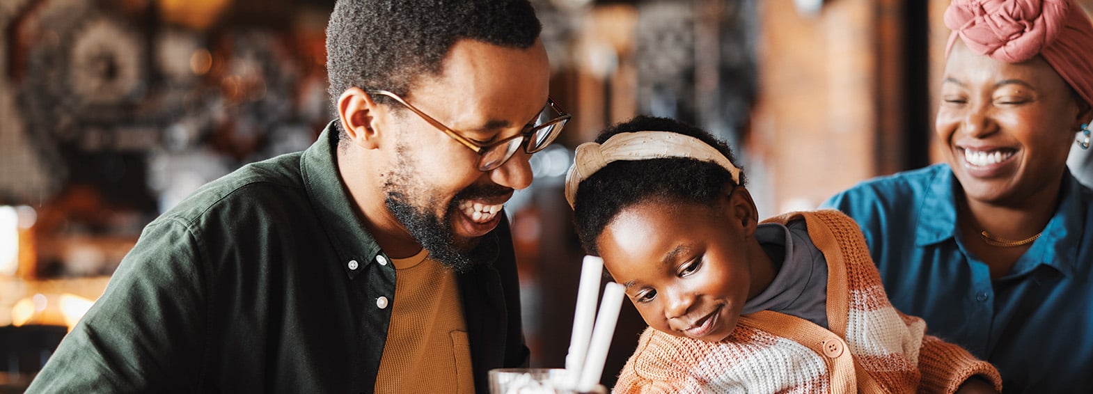 Happy family of three enjoying meal at restaurant
