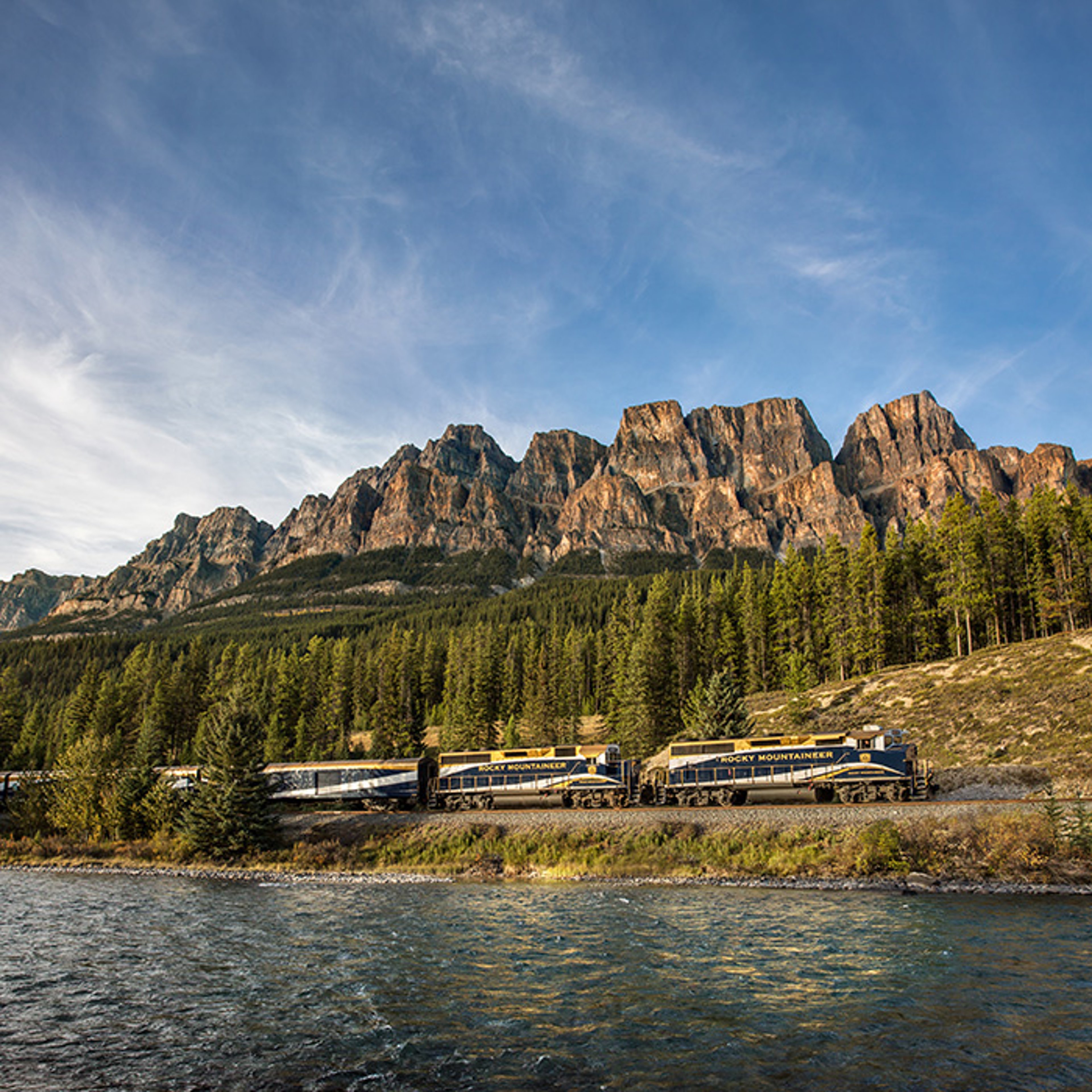 Scenic view of Rocky Mountaineer train winding along rocky cliffs overlooking water