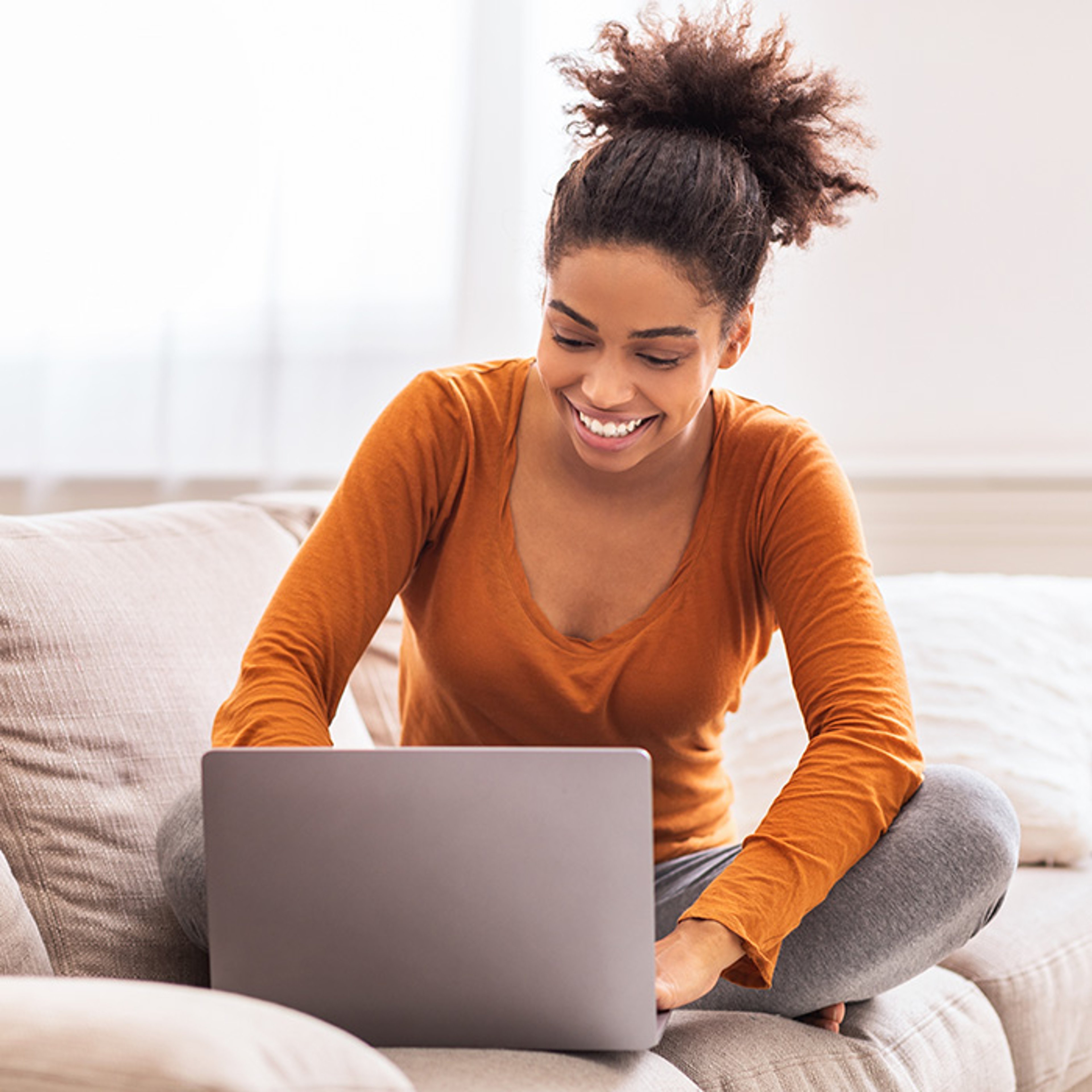 Happy young woman college student doing schoolwork on silver HP laptop