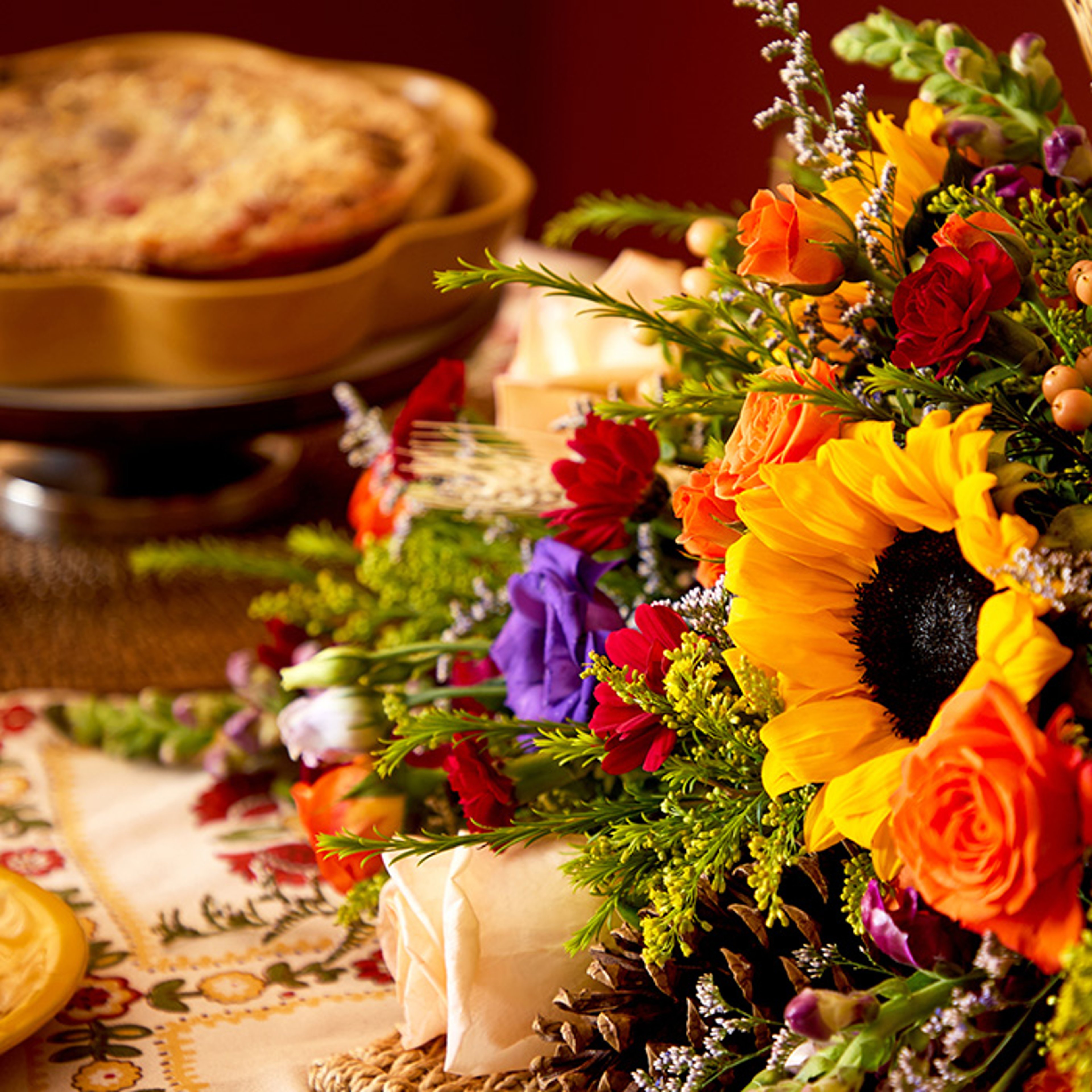Colorful floral fall arrangement with food on banquet table