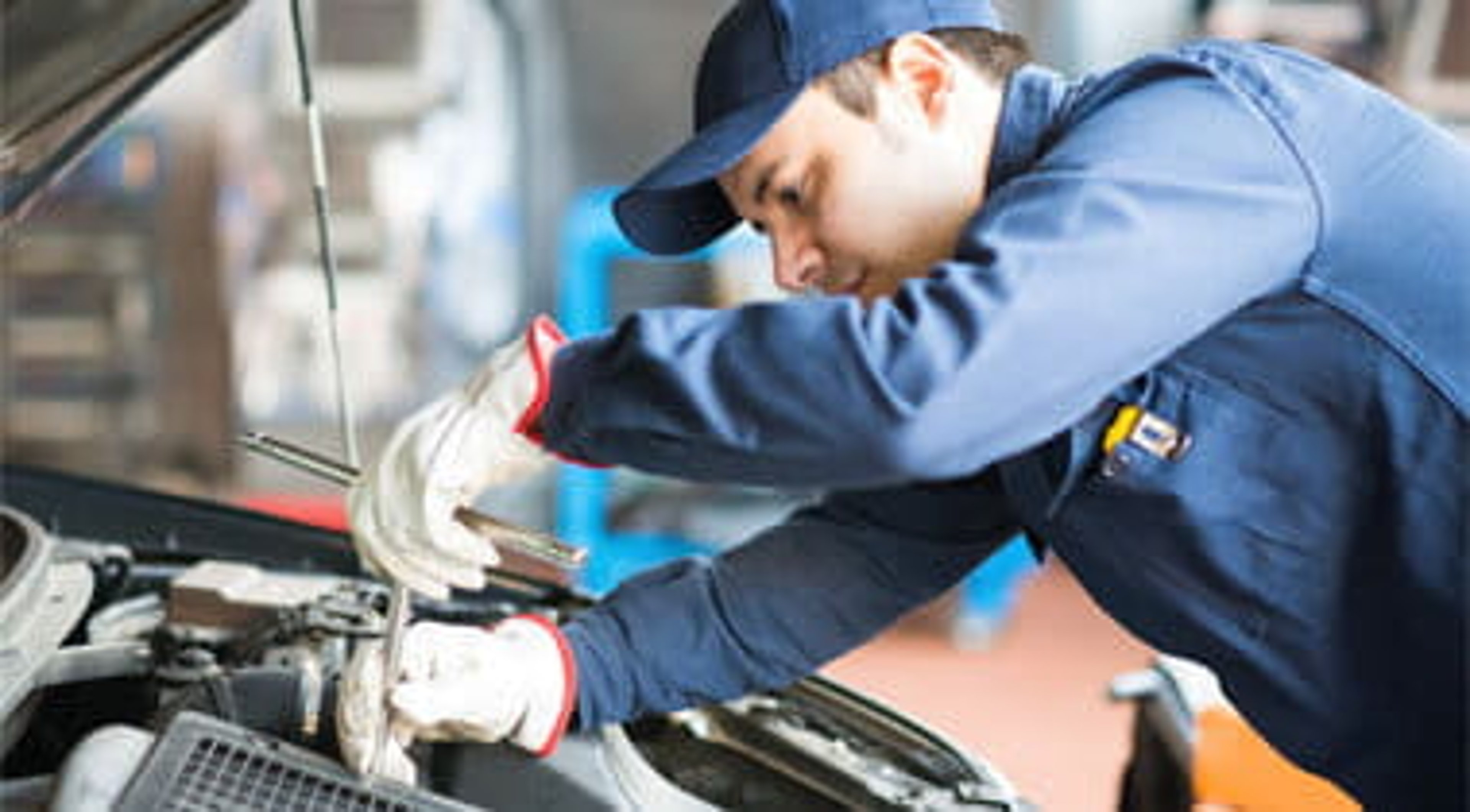 Auto mechanic working on a car in his garage