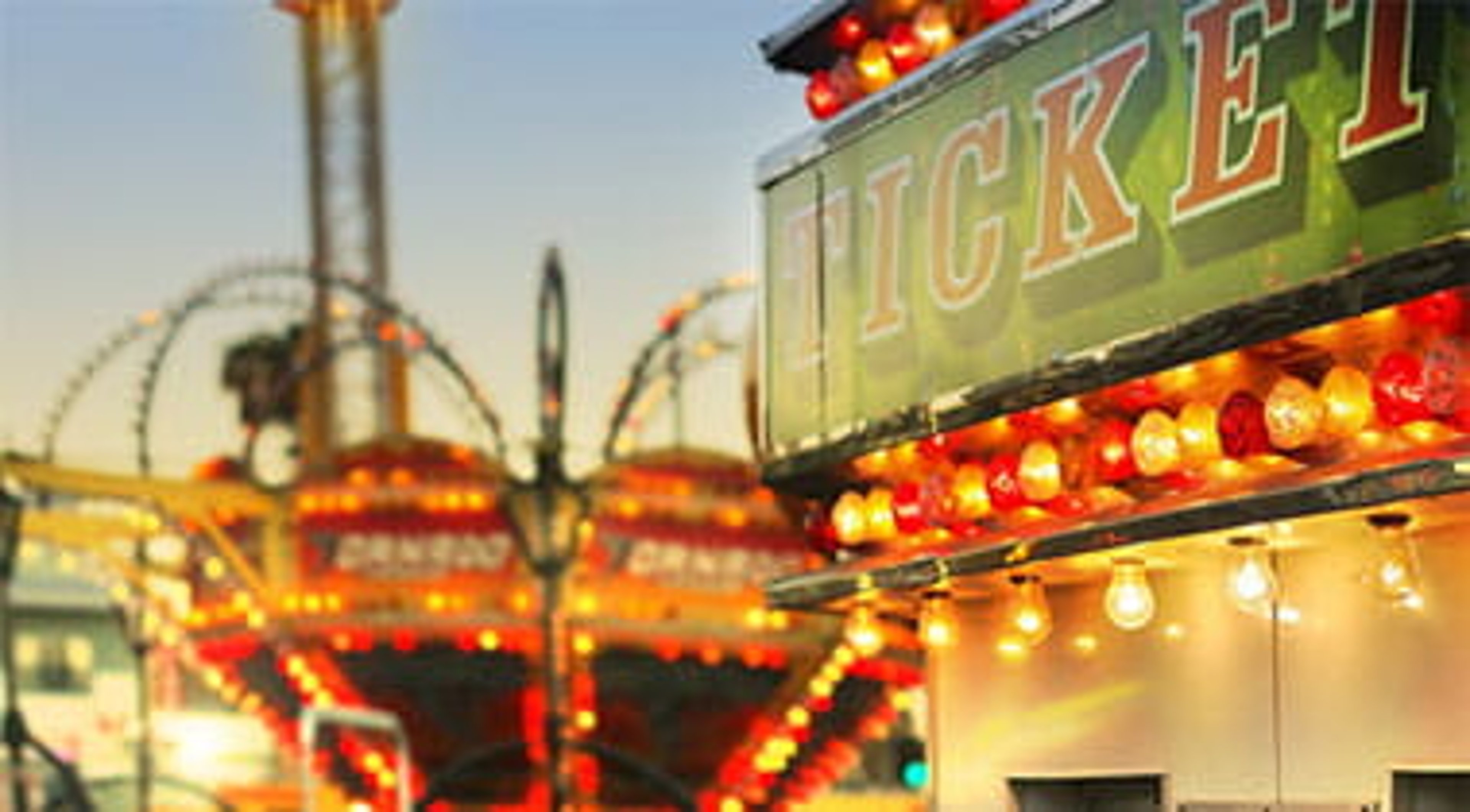 Scene at a classic carnival with a ticket booth in the foreground.