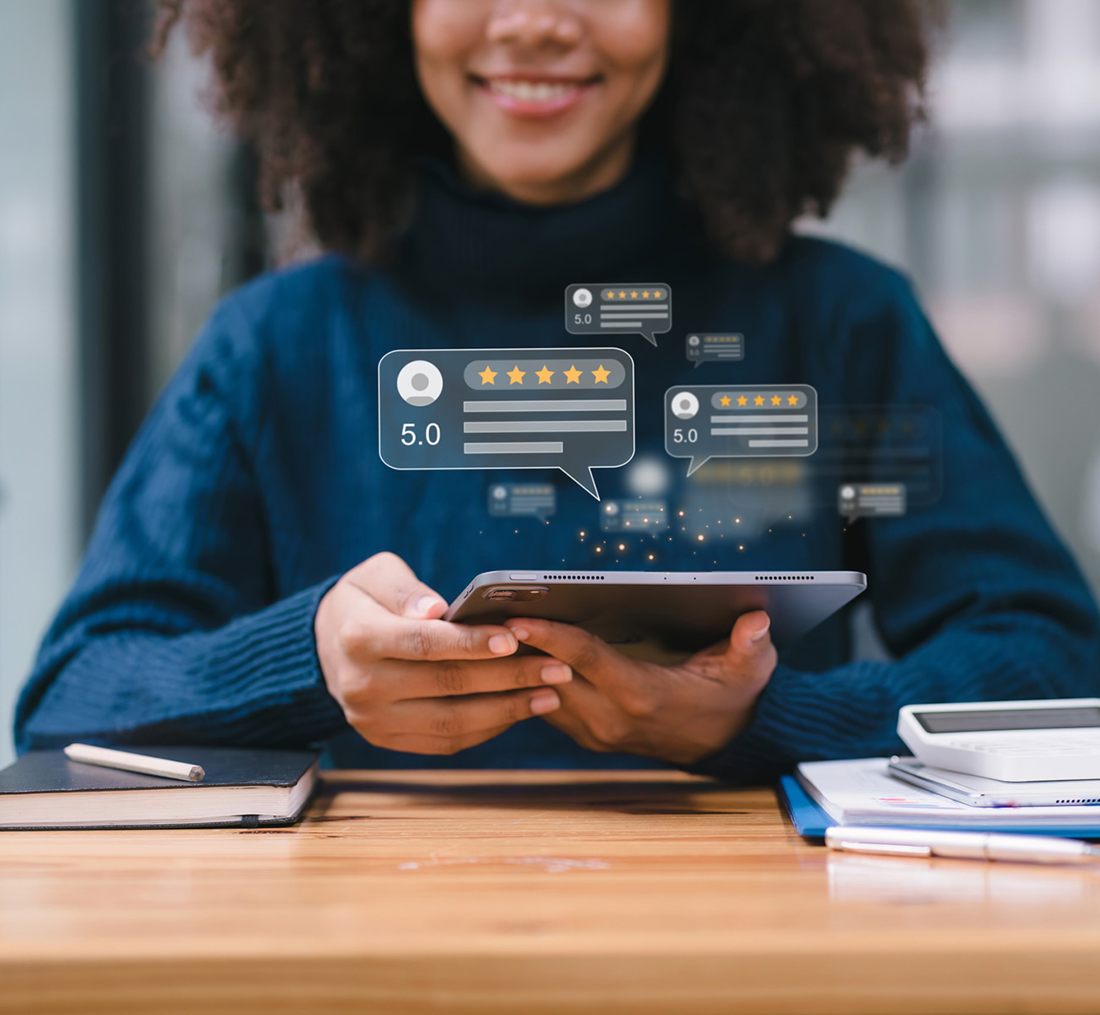 Smiling young woman holding tablet with hovering superimposed icons of 5 star reviews