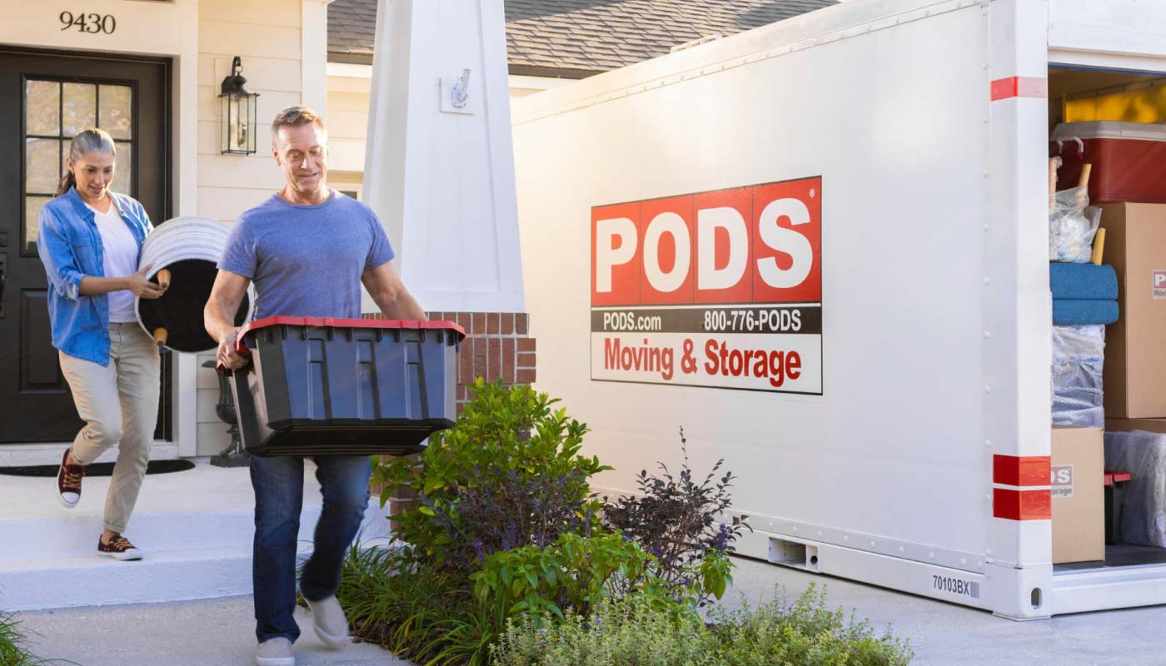 Family moving items into PODS storage box