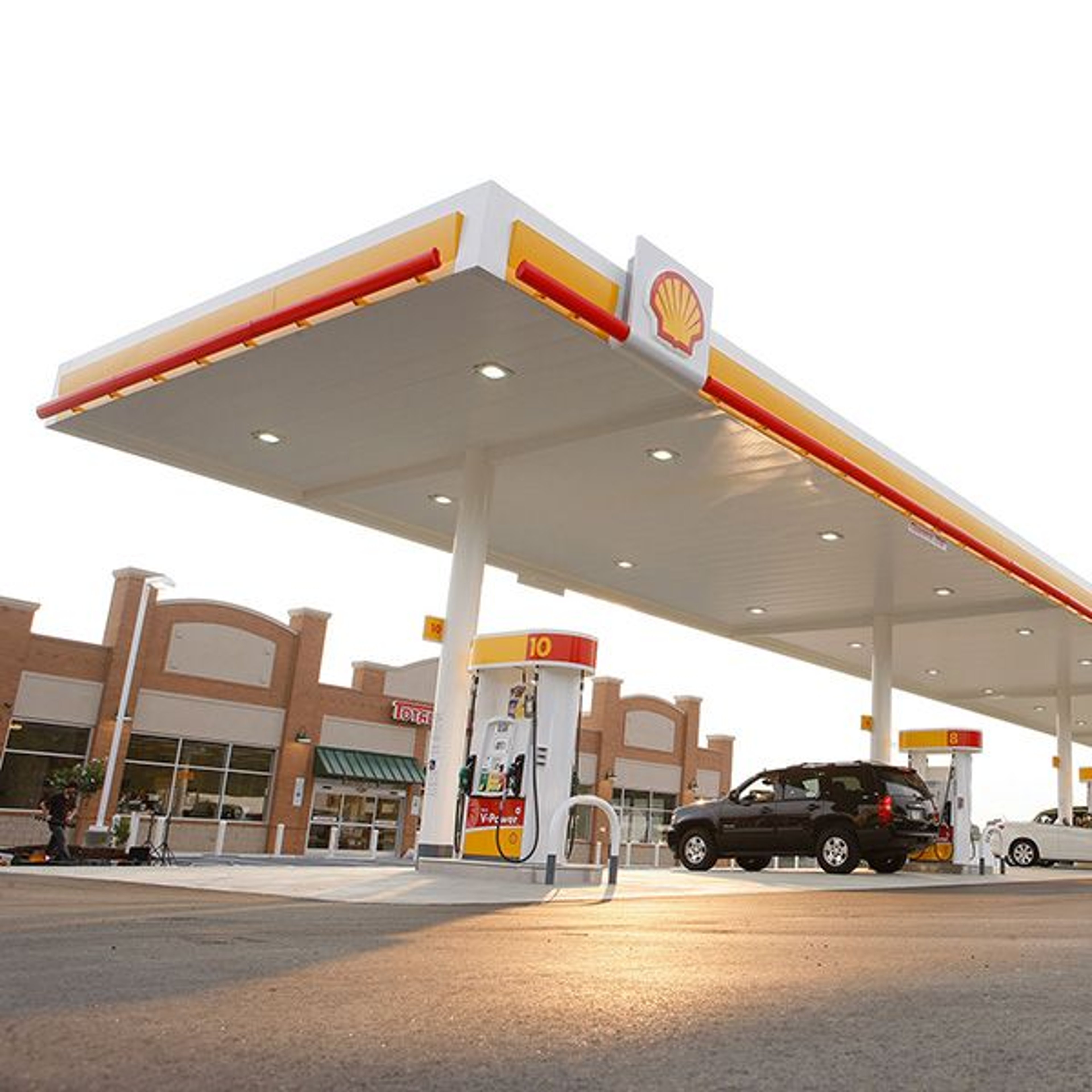 Shell gas station at dusk with vehicles getting fuel