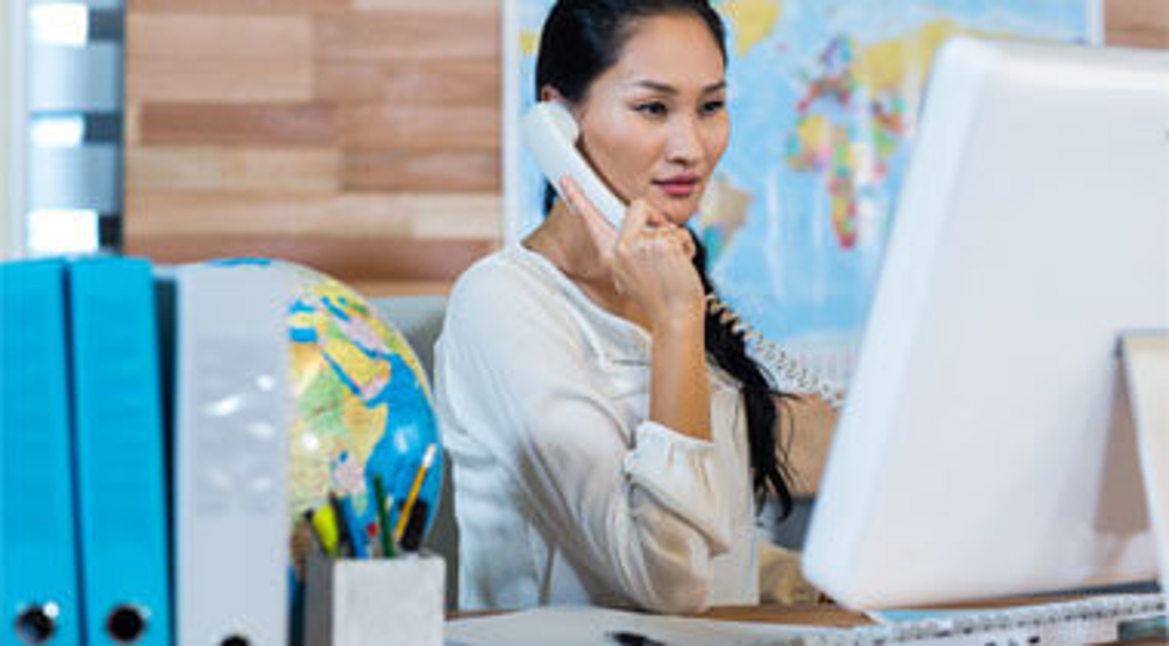 Women on a phone call looking at the computer in the office