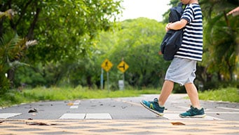 Illustration of kids crossing the street with crossing guard holding a stop sign