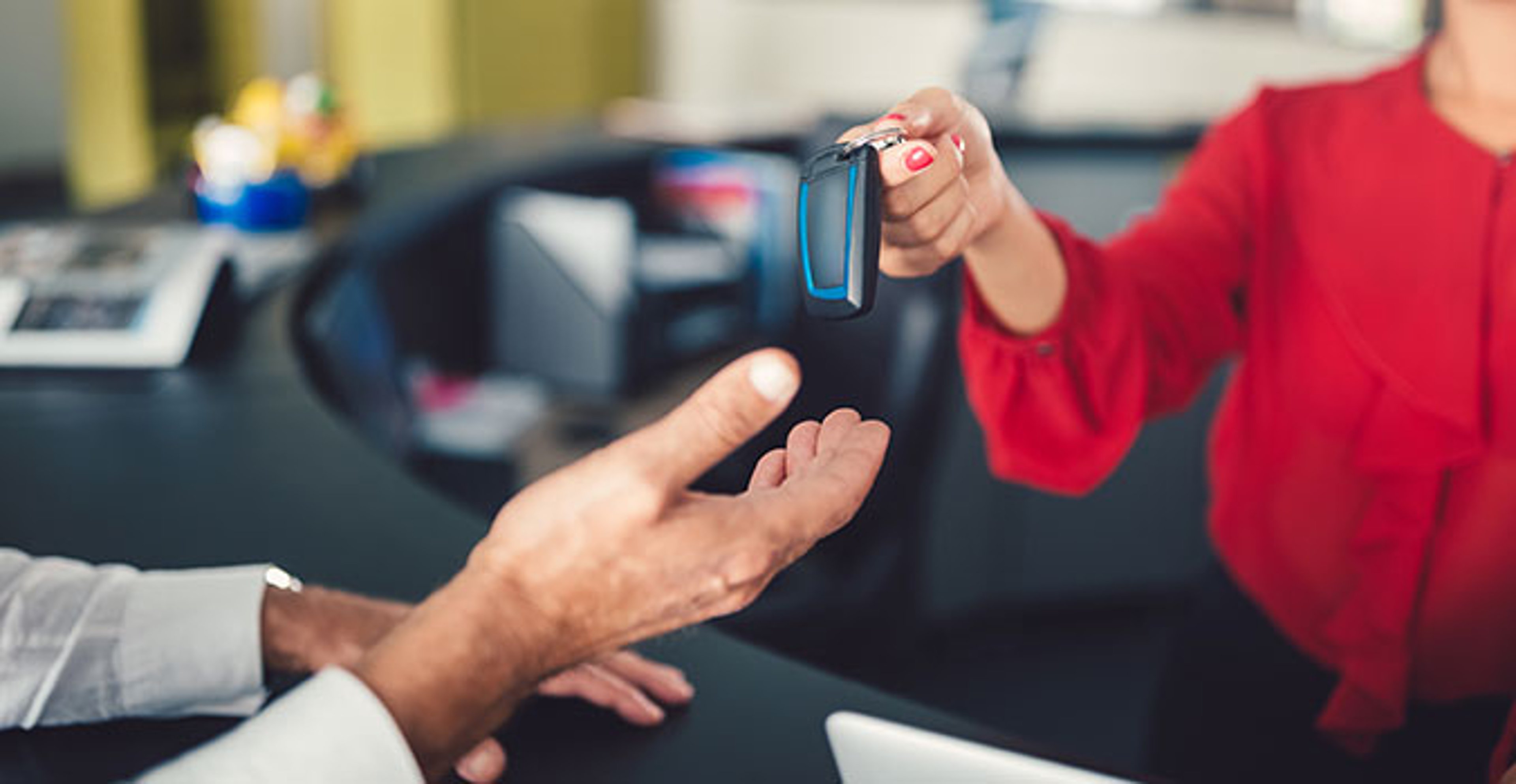 person handing a driver the keys to a car