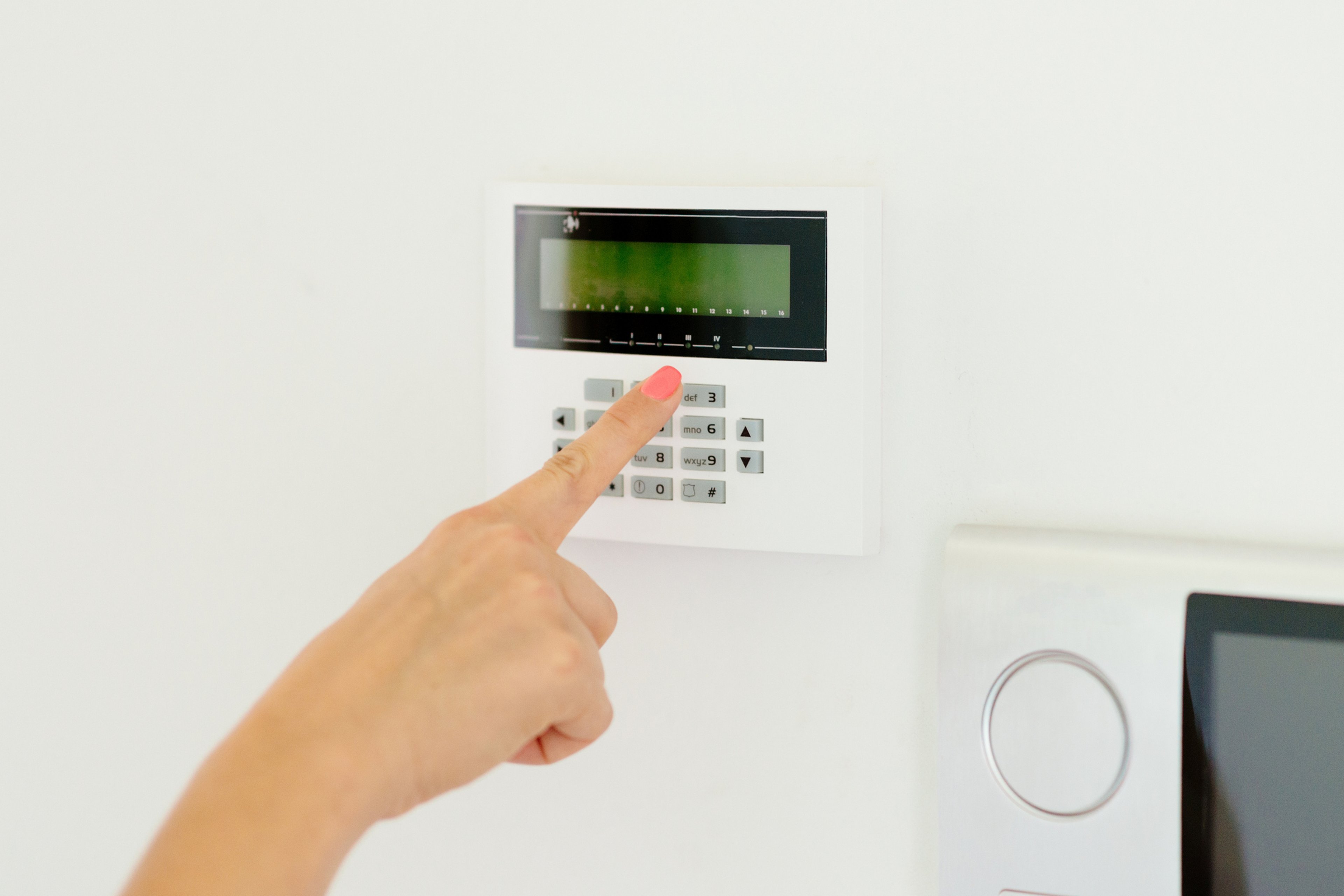 Woman pushing button on home security system