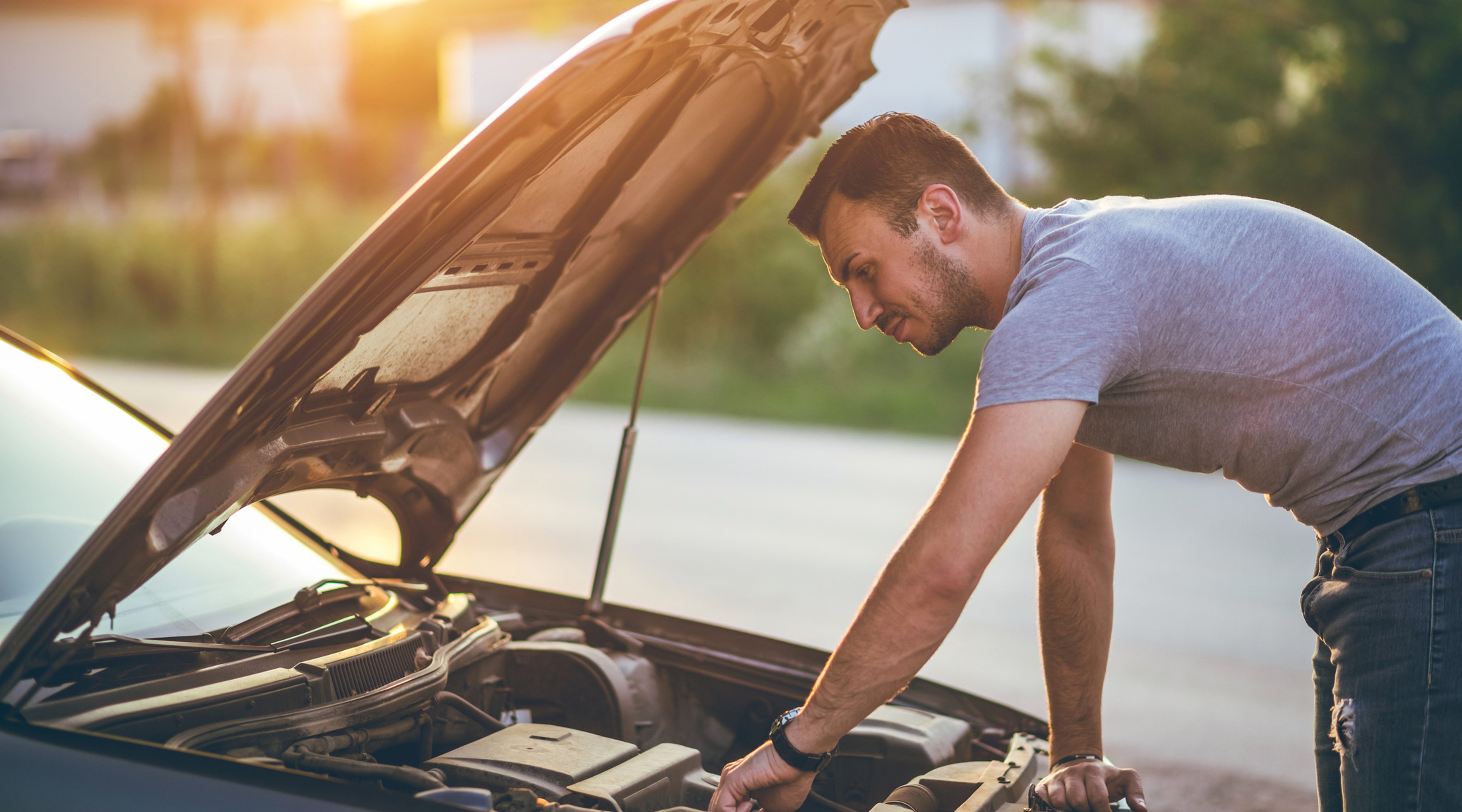 Man working under the hood of his car