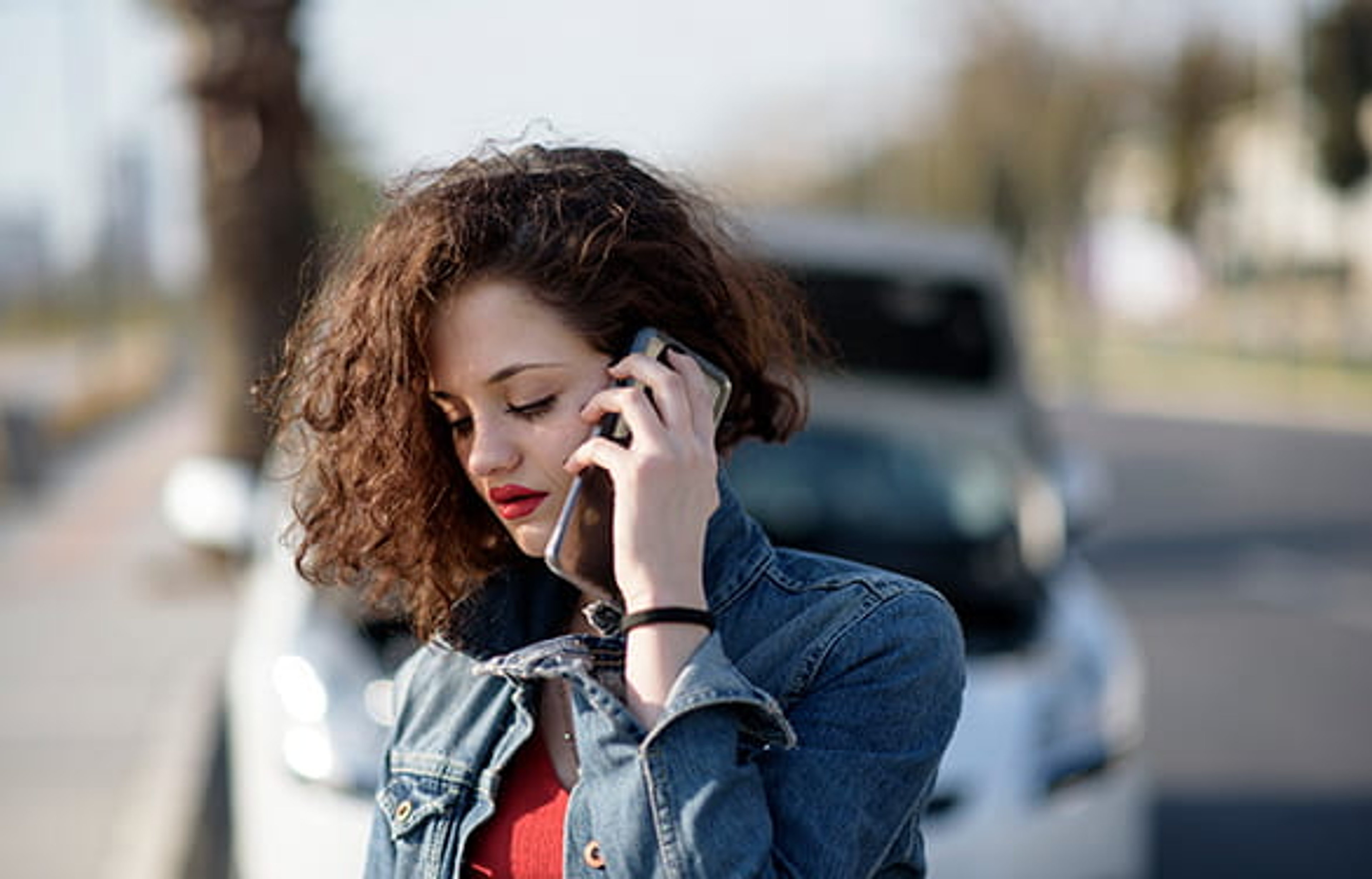 Woman on phone in front of disabled vehicle
