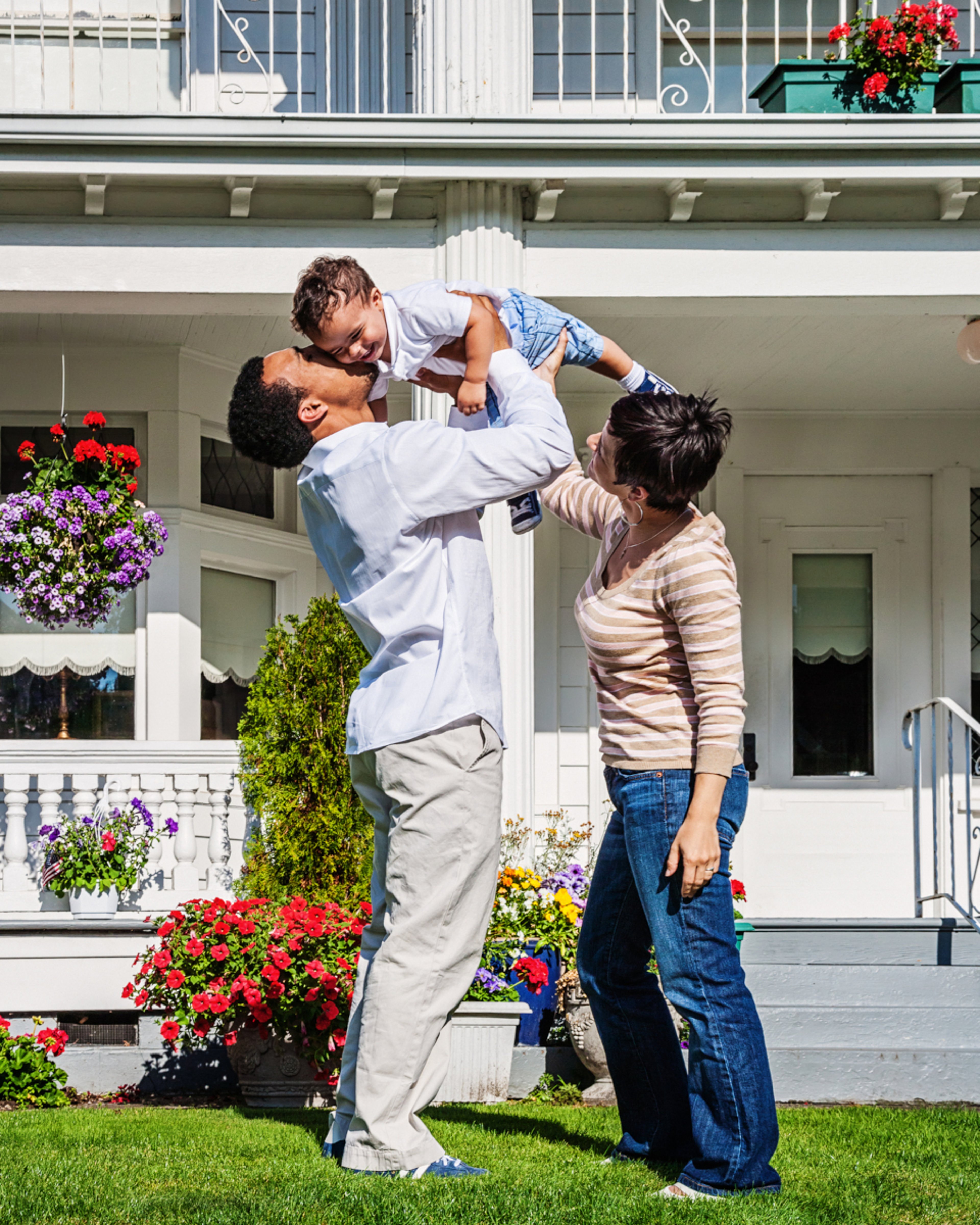 Couple playing with small child in front yard