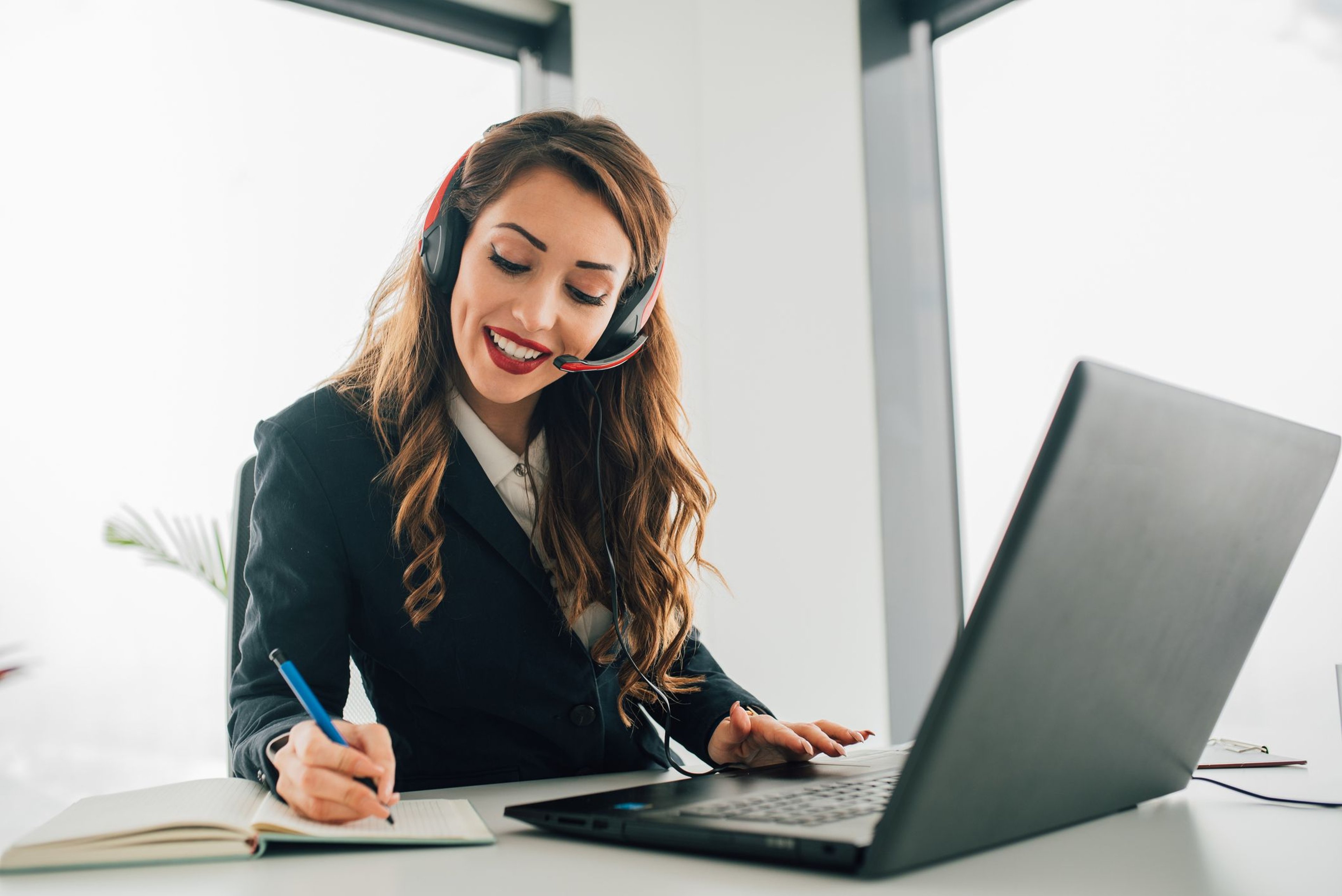 Insurance agent taking call on headset using laptop