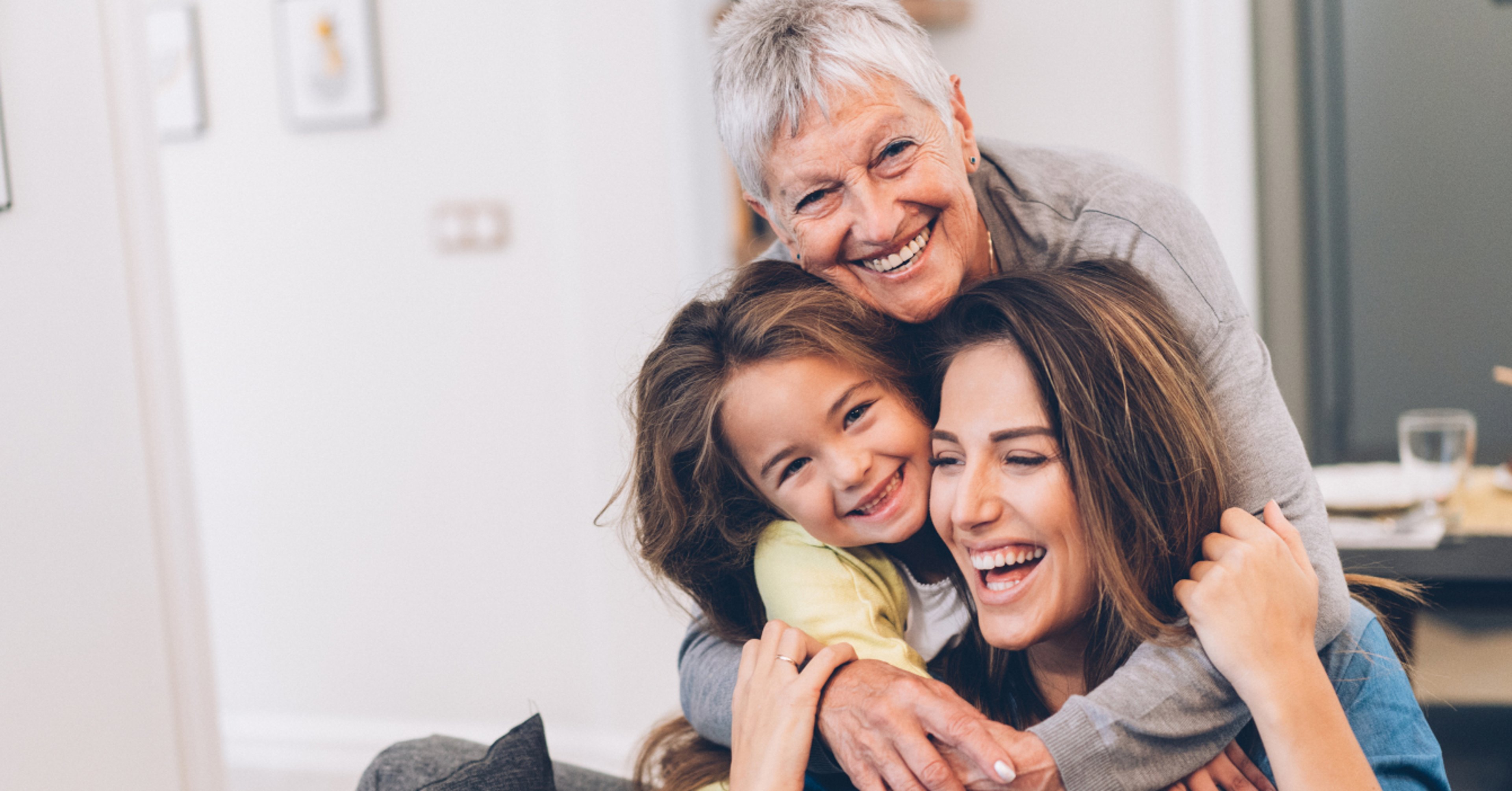 Three generations of women smiling and embracing