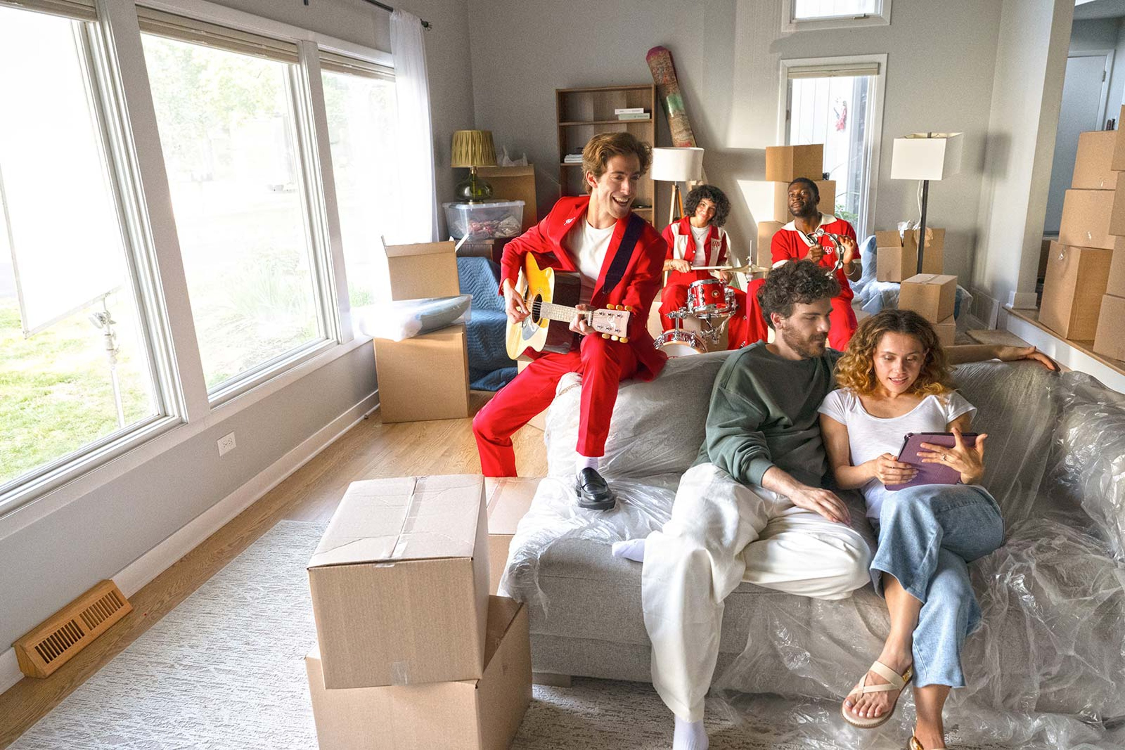 Couple unpacking in the living room with a band playing