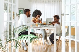 Family of three sitting at table enjoying breakfast